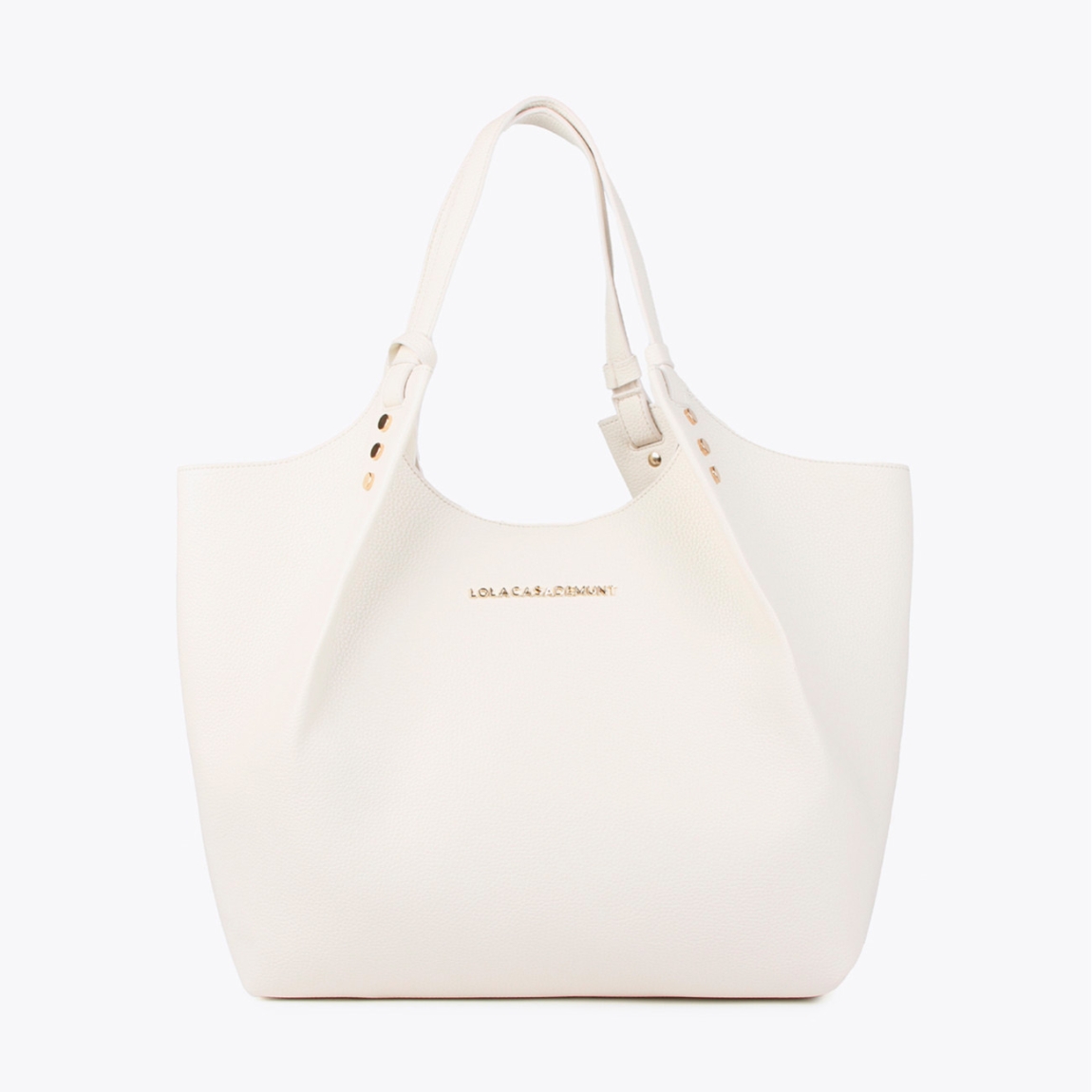 Bolso shopper de la marca Lola Casademunt, modelo ELLIE. Exterior en piel color blanco y detalles de tachuelas planas. Contiene pouch interior. Cierre imantado. Asa de hombro. Las medidas son ALTO: 37 cm - LARGO: 34 cm - ANCHO: 16 cm / BANDOLERA: 87 cm. Este bolso shopper Lola Casademunt ELLIE es un complemento ideal para llevar todos tus esenciales a donde vayas!