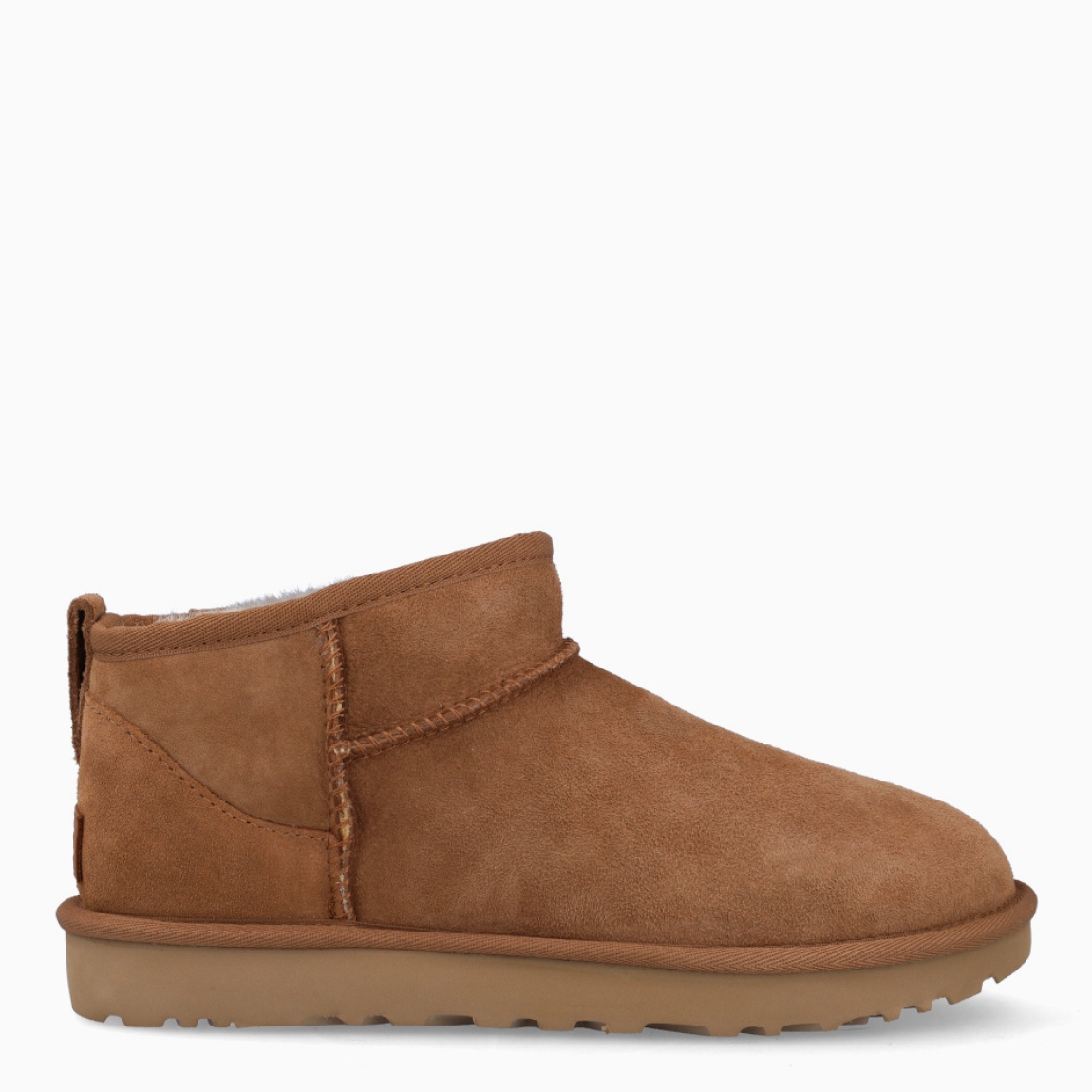 Botines CLASSIC ULTRA MINI de la marca UGG, en color CHESTNUT. Exterior en ante de piel de oveja color marrón claro. Tratamiento higrófugo aplicado en el exterior. Forro y plantilla de pelo de oveja acolchado. Suela plana de goma EVA de caña de azucar. Altura de la caña 8,9cm. Estos botines UGG Classic Ultra Mini son uno de los clásicos más codiciados de UGG, un diseño con una caña más baja que facilita ponérselas y quitárselas.