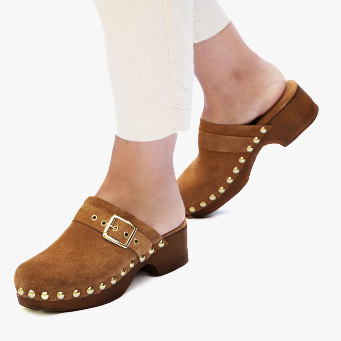Zuecos de la marca Itse, modelo MIRKO. Exterior de los zuecos en ante color cuero con detalle de tachuelas y hebilla. Interior de los zuecos en ante color cuero. Zuecos Itse con tacón de 4cm de altura. Estos zuecos Itse MIRKO son un complemento tendencia de temporada, podrás crear diferentes looks con la máxima comodidad posible.