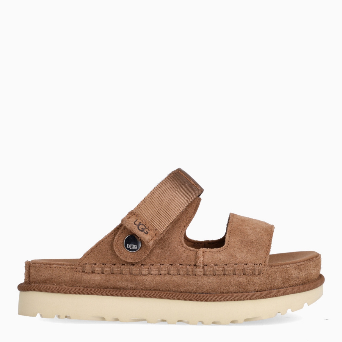 Sandalias de la marca UGG, modelo GOLDEN. Elaboradas en ante color cuero con tiras en la pala, y cierre con velcro. Estas sandalias UGG son ligeras y muy cómodas gracias a la suela de EVA de caña de azúcar y la plantilla contorneada, que las hacen ideales para explorar la ciudad o cualquier otro destino. Las tiras están hechas de una combinación de nobuk suave y piel auténtica. Estas UGG GOLDEN, que cuentan con elementos emblemáticos como los ribetes con costuras te permiten disfrutar de la increíble sensación UGG también durante los meses más cálidos.