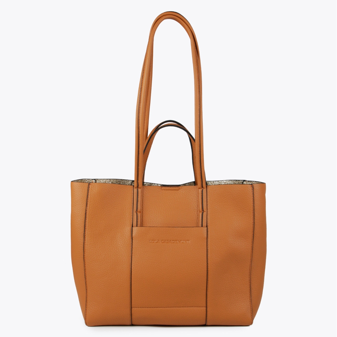 Bolso shopper de la marca Lola Casademunt, modelo KERENT. Exterior en piel color camel con interior en material glitter dorado. Contiene distintos compartimentos interiores y bolsillos con cremallera. Contiene asa bandolera ajustable. Cierre imantado. ALTO: 28 cm - LARGO: 45 cm - ANCHO: 12 cm / BANDOLERA: 28 cm. Este bolso Lola Casademunt KERENT es el complemento ideal para llevar todos tus esenciales en tu día a día!