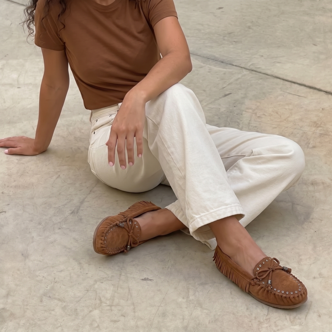 Mocasines de la marca Itse, modelo MACARENA. Elaborados en ante color camel con detalle corrugado en punta y flecos a los costados. Además de tachuelas plateadas y lazo en la pala. Interior en piel color camel. Suela de goma plana. Mocasines Itse MACARENA son un complemento clásico, e ideal para la comodidad de tu día a día!