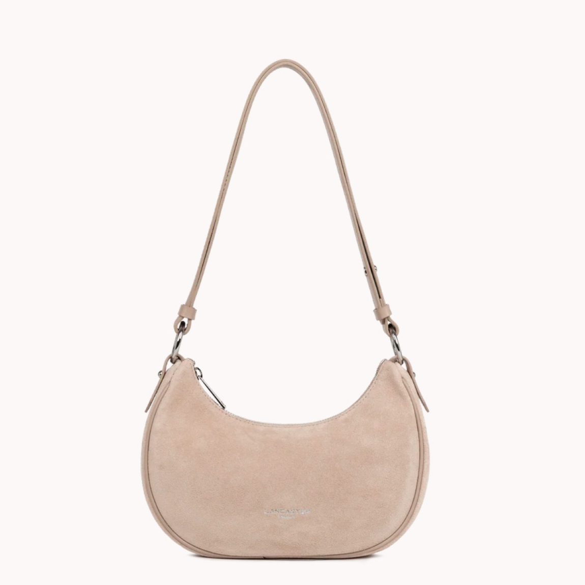 Este pequeño bolso bandolera de la marca Lancaster, modelo Suède está confeccionado en cuero de vaca con efecto ante de color beig. Incluye un bolsillo interior simple, un bolsillo interior con cremallera y un bolsillo trasero exterior con cremallera. Se puede llevar al hombro o cruzado. Bolso con logotipo en parte frontal. Bolso Lancaster Suède se ha convertido en un complemento ideal para llevar a todos lados, su forma en media luna le da un estilo único!