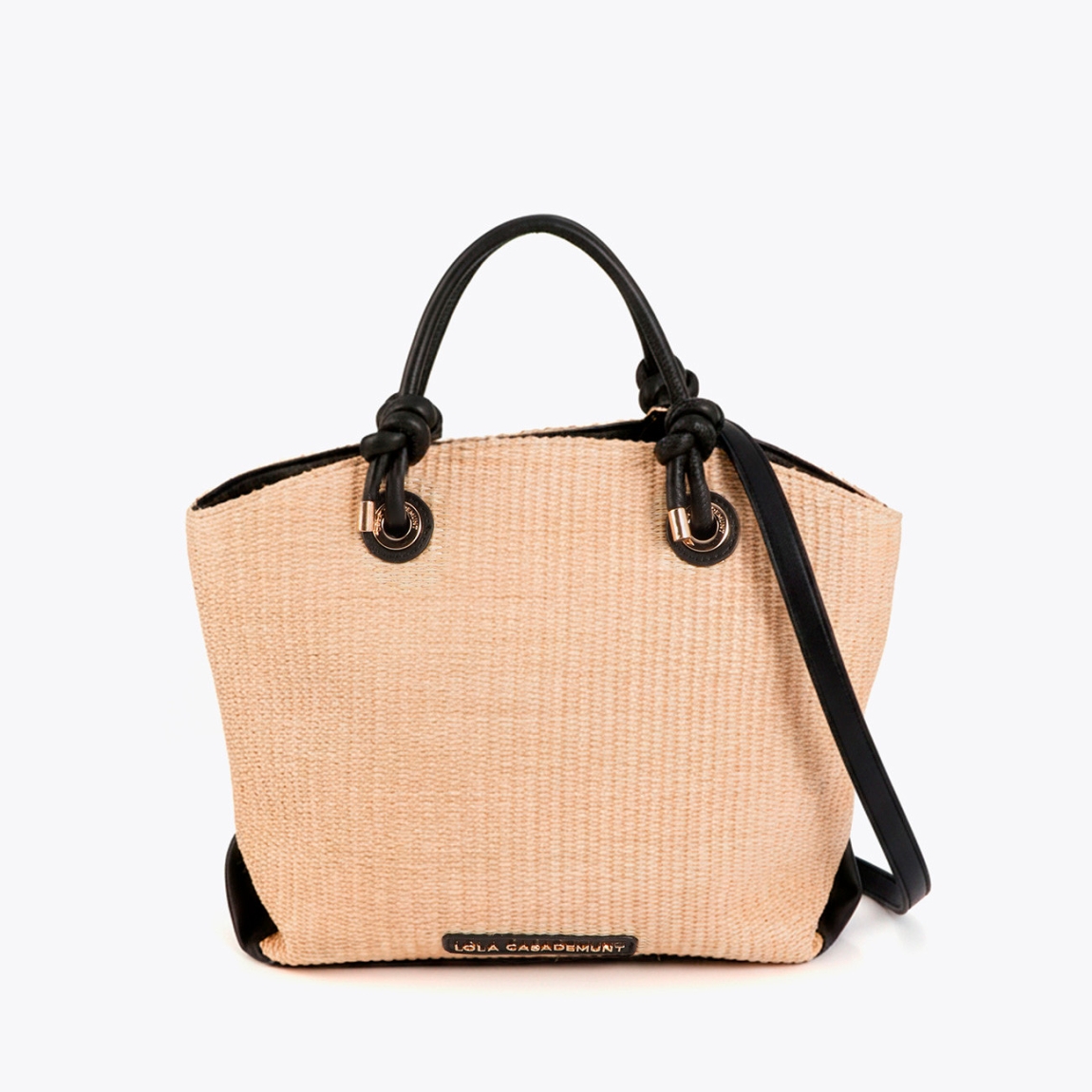 Bolso tipo capazo con efecto rafia de la marca Lola Casademunt, modelo LUCIANA. Bolso elegante y versátil. Asa doble en negro con detalles en dorado. Interior amplio con cierre de cremallera y forro suave. Bolso Lola Casademunt, LUCIANA, ideal para complementar tus looks veraniegos con un toque chic.ALTO 29cm- ANCHO 32cm PROFUNDIDAD 12.5cm