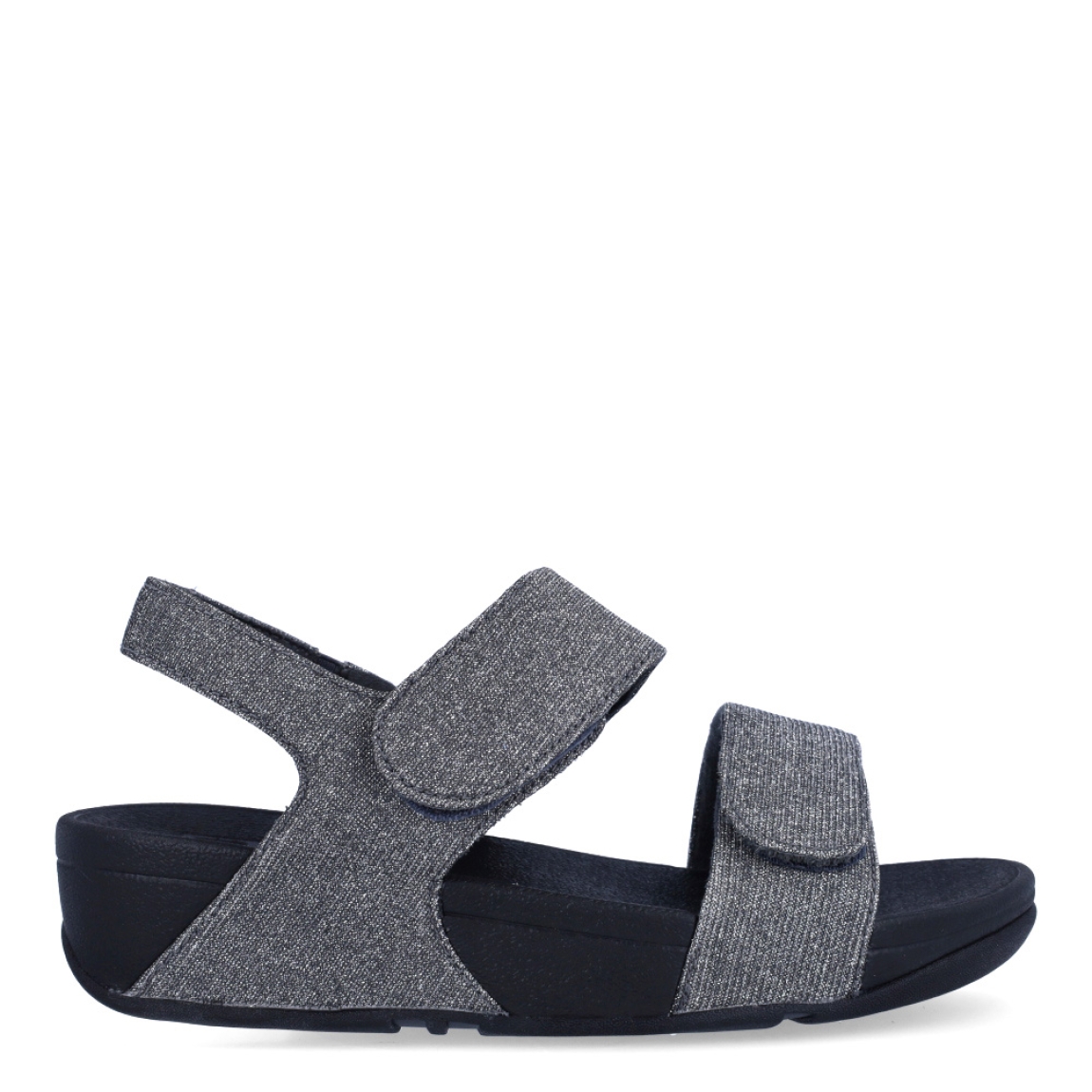 Sandalias de la marca Fitflop, modelo LULU ADJUSTABLE. Exterior en neopreno color gris, decorado con brillantes en pala. Interior en microfibra de color negro. Cierre con doble velcro en la pala. Suela de caucho antideslizante y planta acolchada. Cuña de 4 cm incluyendo 2,5 cm de plataforma. Con detalle de piel sintética perlada metalizada en los laterales. Fabulosas de día y de noche.