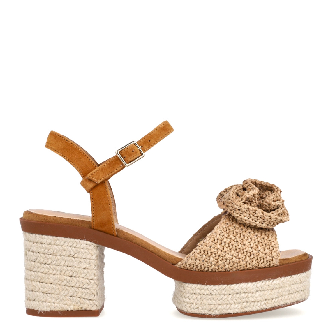 Sandalias de la marca Gaimo, modelo Luana. Elaboradas en rafia colo camel, combinan elegancia y comodidad con su propuesta en rafia natural, con un delicado adorno de flor y talón abierto con pulsera ajustable. Cierre con hebilla en tobillo y un tacón de 8cm de altura. Elaboradas artesanalmente en Arnedo, España, con materiales de alta calidad y 100% naturales, las sandalias Luana son la opción perfecta para quienes buscan elevar sus looks veraniegos.