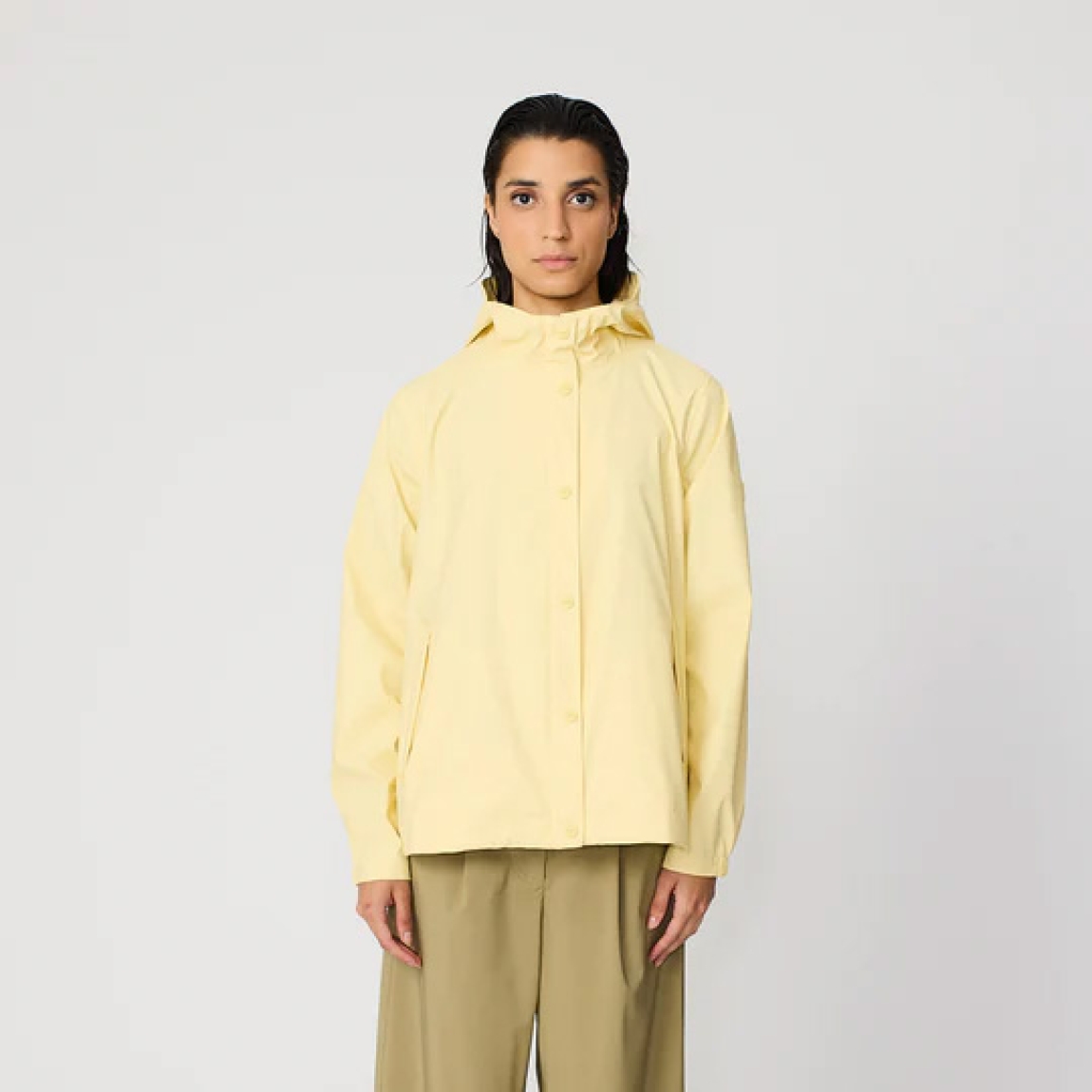 Chaqueta lisa de la marca Tanta, modelo NIMBUSELLE. Chaqueta impermeable ligera y moderna confeccionado en poliuretano fino color amarillo. Una versión más liviana de nuestro material icónico, ideal para los días cálidos y húmedos de primavera y verano. 100 % waterproof, con todas las costuras selladas, presenta una silueta joven y un bajo redondeado, ideal para el uso diario en días de lluvia y temperaturas suaves. Chaqueta Tanta NIMBUSELLE ideal para esta temporada!