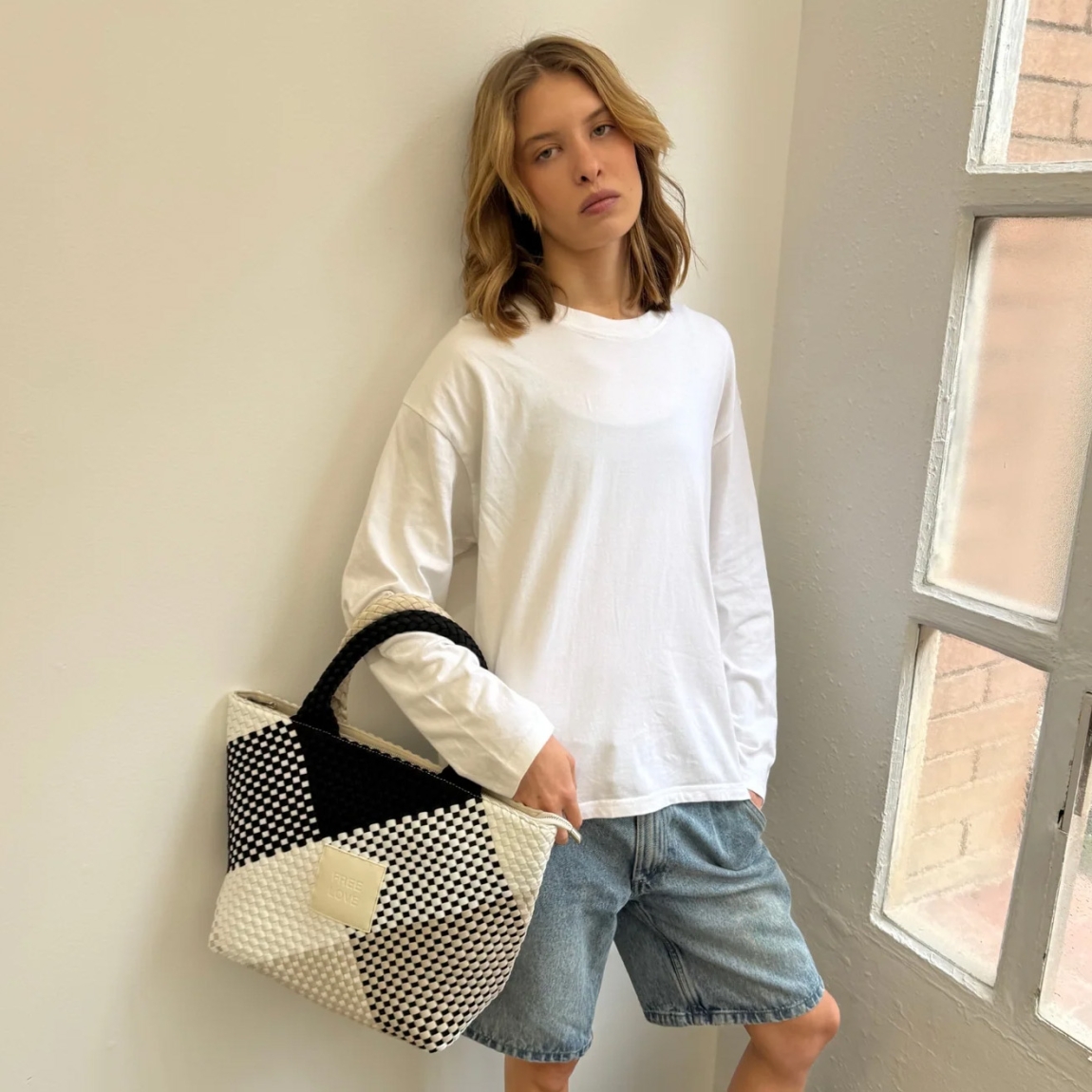 Bolso de la marca VTD, modelo MARAN. Bolso elaborado en neopreno trenzado color blanco y negro, realizado a mano, aporta textura, carácter y una estética atemporal. Un bolso funcional, pero también consciente. Este bolso VTD incorpora una correa ajustable a juego con el color del bolso, que se puede enganchar en el interior, para llevar el bolso al hombro o cruzado, según cómo te muevas. En el interior, varios compartimentos que invitan a ordenar sin esfuerzo, porque cuando todo fluye, tú también. Este bolso VTD, modelo MARAN, está pensado para los días que no tienen un sólo contexto: Para moverte, para cambiar de planes, para llevar lo importante y casi todo lo que quieras contigo!Medidas: alto 27cm y ancho 40cm.