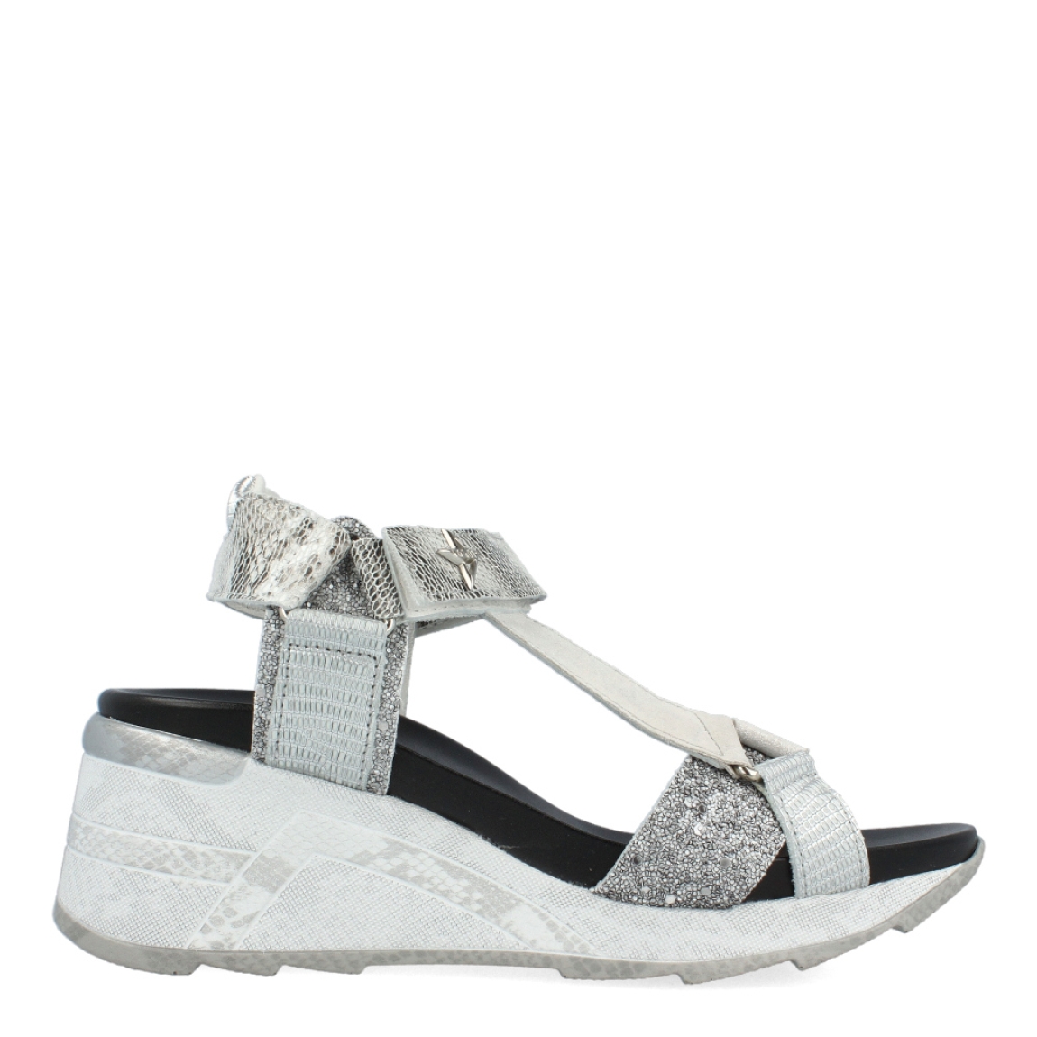 Sandalias de la marca Cetti, modelo SAGA. Exterior de las sandalias en piel color plata. Interior de las sandalias en piel color negro. Cierre de las sandalias con velcro en el tobillo. Sandalias Cetti con cuña de 5cm de altura. Estas sandalias Cetti SAGA, tienen el diseño perfecto para lucirlas con estilo y comodidad.