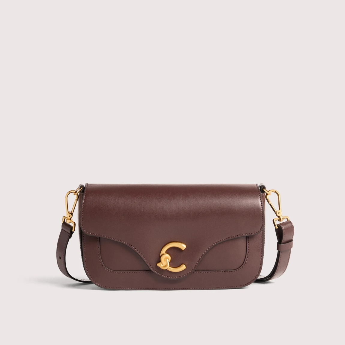 Bolso de la marca Coccinelle, modelo C-ME. Bolso elaborado en piel color burdeos con adorno dorado de logotipo marca. Las líneas geométricas y las elegantes curvas realzan el diseño. Cierre con imán y asa de hombro. Modelo C-ME con un tamaño perfecto para funcionalidad y elegancia. Bolso Coccinelle, modelo que te aportará a tus looks un estilo discreto y refinado. Medidas: alto 15cm y ancho 26cm.