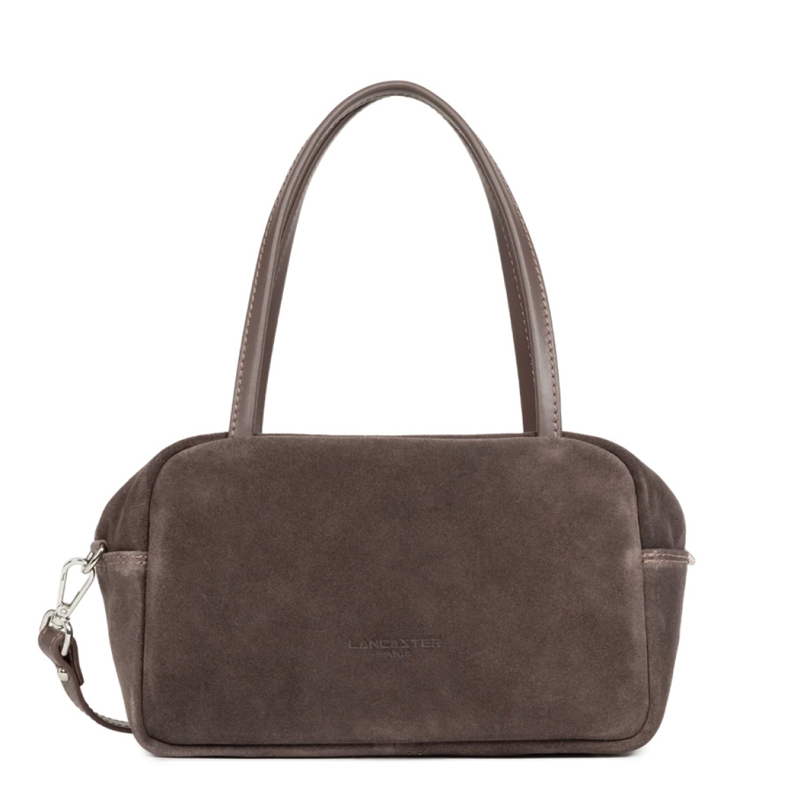 Bolso de mano de la marca Lancaster, modelo SUÈDE IT. Bolso confeccionado en piel de vacuno efecto terciopelo color marrón oscuro, ofreciendo un tacto suave y un specto elegante. Cuenta con un bolsillo trasero con cremallera, un bolsillo interior con cremallera y un bolsillo sencillo para organizar tus esenciales. Su cierre con cremallera garantiza seguridad y practicidad en el día a día. Bolso Lancaster equipado con una bandolera extraíble y ajustable, se lleva principalmente en la mano y también puede llevarse al hombro o cruzado. Medidas: alto 15cm y ancho 25cm.