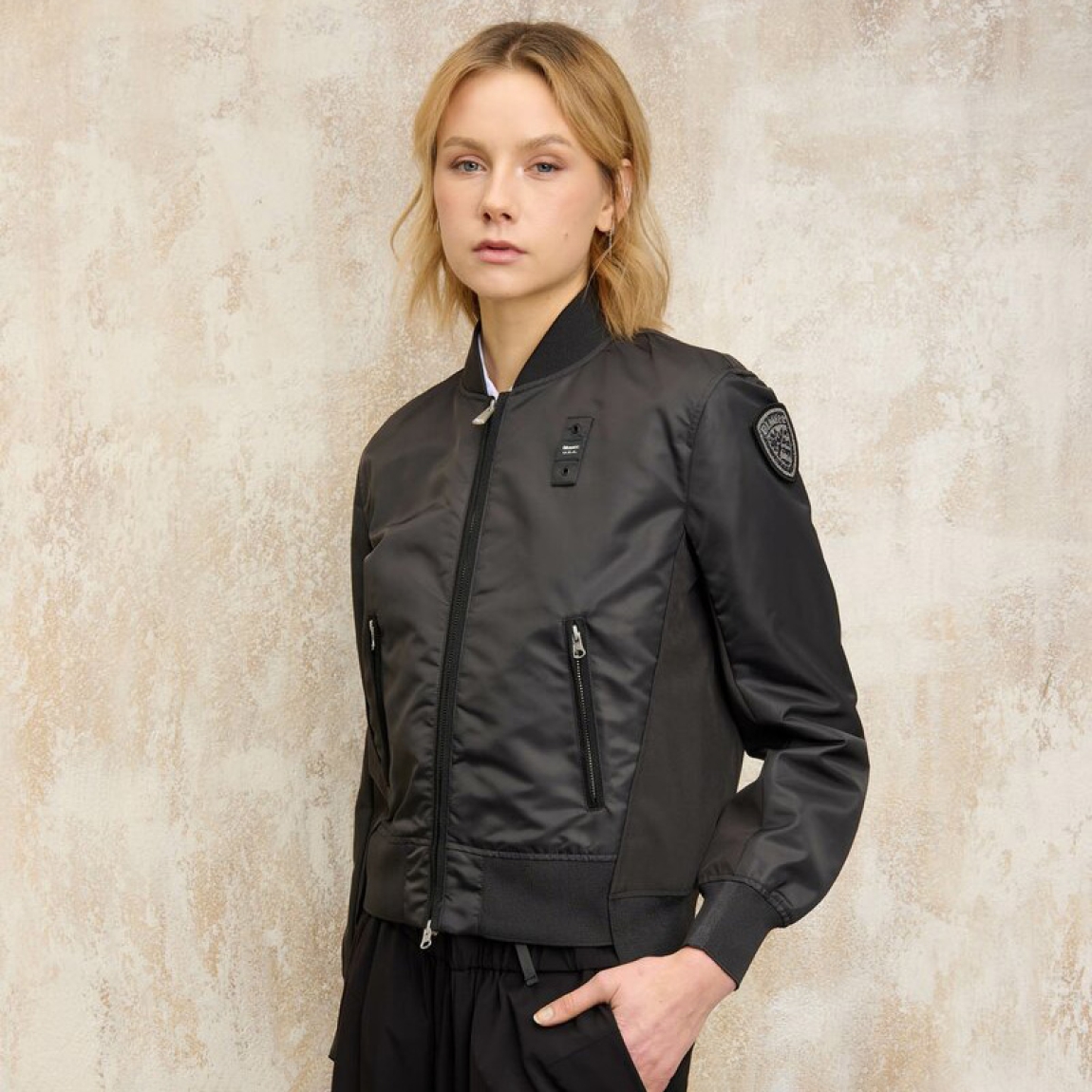 Bomber de de la marca Blauer, modelo LAURIE. Chaqueta corta lisa en nylon brillante color negro y cepillado en la parte delantera y de neopreno a tono en la parte trasera, debajo de las mangas y en la protección de la cremallera delantera. Prenda ligeramente más larga en la parte trasera para dar movimiento. Cierre con cremallera. Bolsillos con cremallera. Costilla en el cuello, en los puños y en el fondo. Bolsillos interiores con velcro. Parche y pasante con logotipo. Chaqueta Blauer ideal para esta temporada!