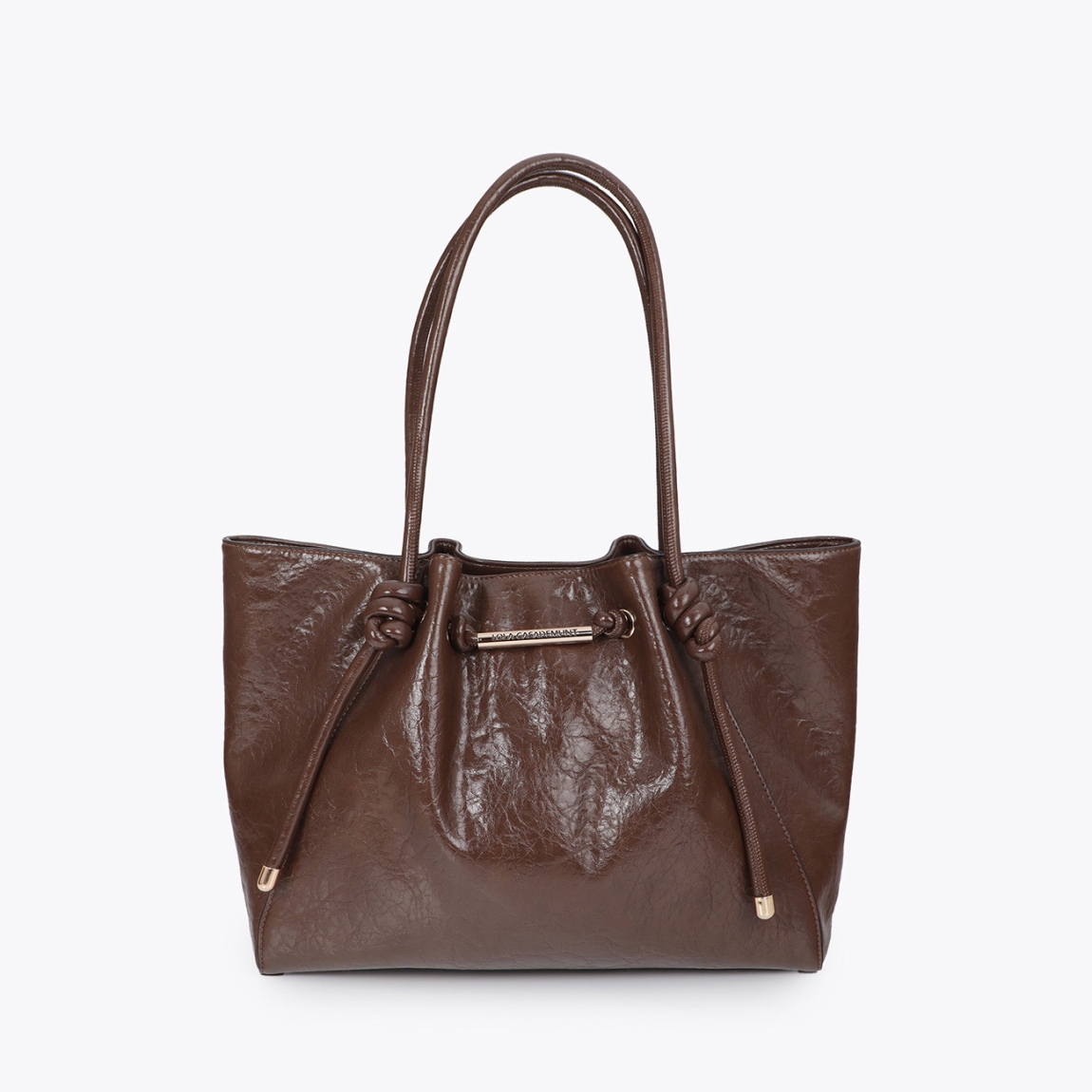 Bolso shopper de diseño sofisticado de la marca Lola Casademunt, modelo AURI. Bolso elaborado en polipiel en tono marrón con detalle de tubo metálico y logo troquelado. Confeccionado en material resistente, ideal para el uso diario. Asa doble para mayor comodidad y cierre seguro. Bolso Lola Casademunt AUI, perfecto para completar cualquier look casual o de oficina.ALTO 16cm ANCHO 25cm PROFUNDIDAD 12cm