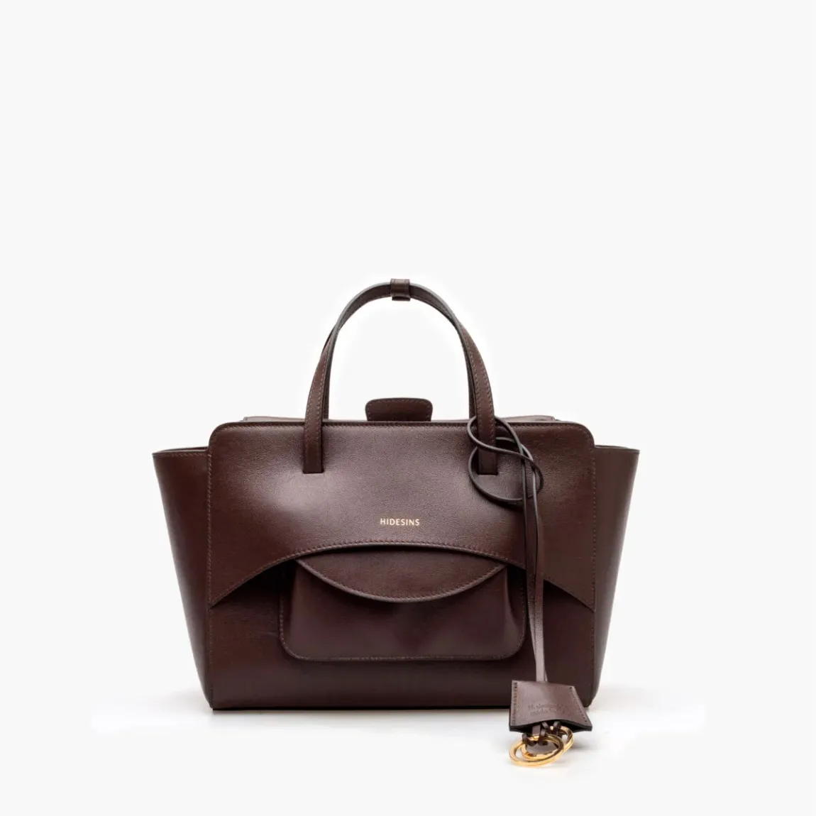 Bolso de la marca Hidesins, modelo FLAP M. Elaborado en piel de alta calidad color marrón con estampado de logotipo en frente. Bolso con botón magnético, correa bandolera ajustable y extraíble. Herrajes metálicos chapados en oro y bolsillos interiores. Medidas: alto 18cm y ancho 26cm. Este bolso Hidesins FLAP M está confeccionado con elegancia, un complemento ideal para resaltar tus looks!