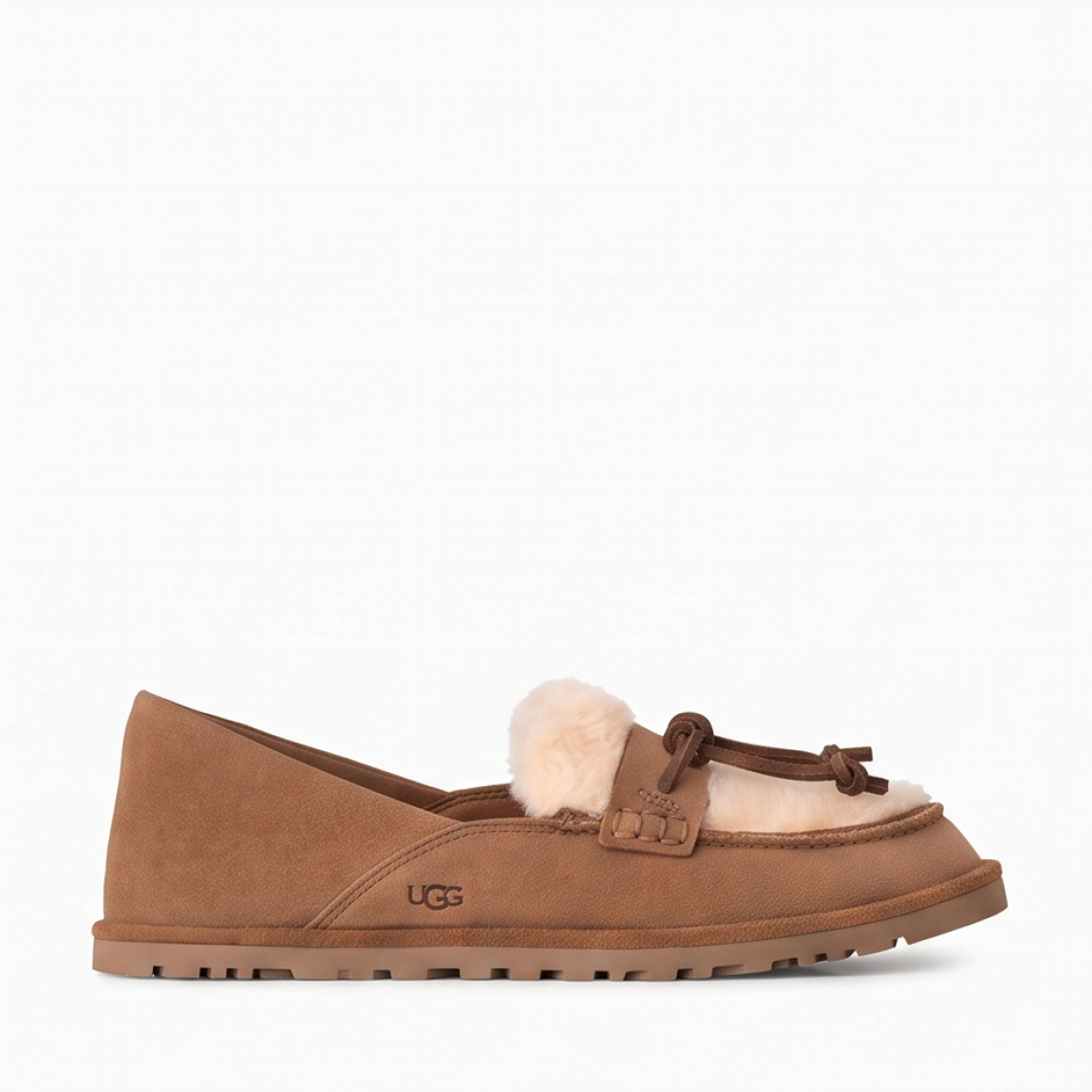 Mocasines de la marca UGG, modelo ZORA. Mocasines elaborados en ante suave color cuero con detalle de lana reciclada UGGplush™ y suave forro de piel de oveja a la vista. Logotipo de UGG grabado en el lateral. Diseño sin cordones con tira y nudo decorativo de piel en el empeine. Suela de goma ligera y dentada para mayor tracción. Perfectos para acompañarte en tu día a día, ideales para combinar con vaqueros rectos o conjuntos casuales tanto en tus planes de fin de semana como en tus paseos por la ciudad. ¡Estos mocasines UGG ZORA son un complemento ideal en comodidad y estilo!