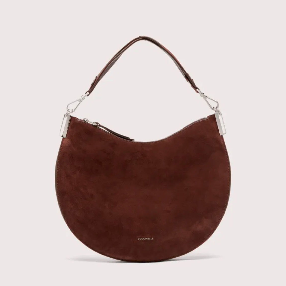 Bolso hobo de la marca Coccinelle, modelo SUNUP. Exterior en ante color marrón con detalle de logo en parte frontal. Interior amplio. Cierre con cremallera y asa de hombro. Medidas: alto 22cm y ancho 33cm. Este bolso Coccinelle SUNUP es un complemento sofisticado, ideal para combinar con tus looks de temporada!
