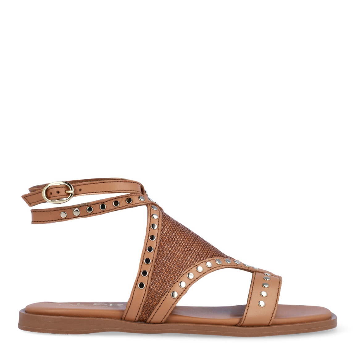 Sandalias de la marca Alpe, modelo GRETHEL. Exterior en piel color camel con detalle de tachuelas doradas y piel efecto rafia en la pala. Interior en piel color camel y cierre en tobillo. Sandalias Alpe con suela plana. Estas sandalias GRETHEL son ideales para esta temporada!