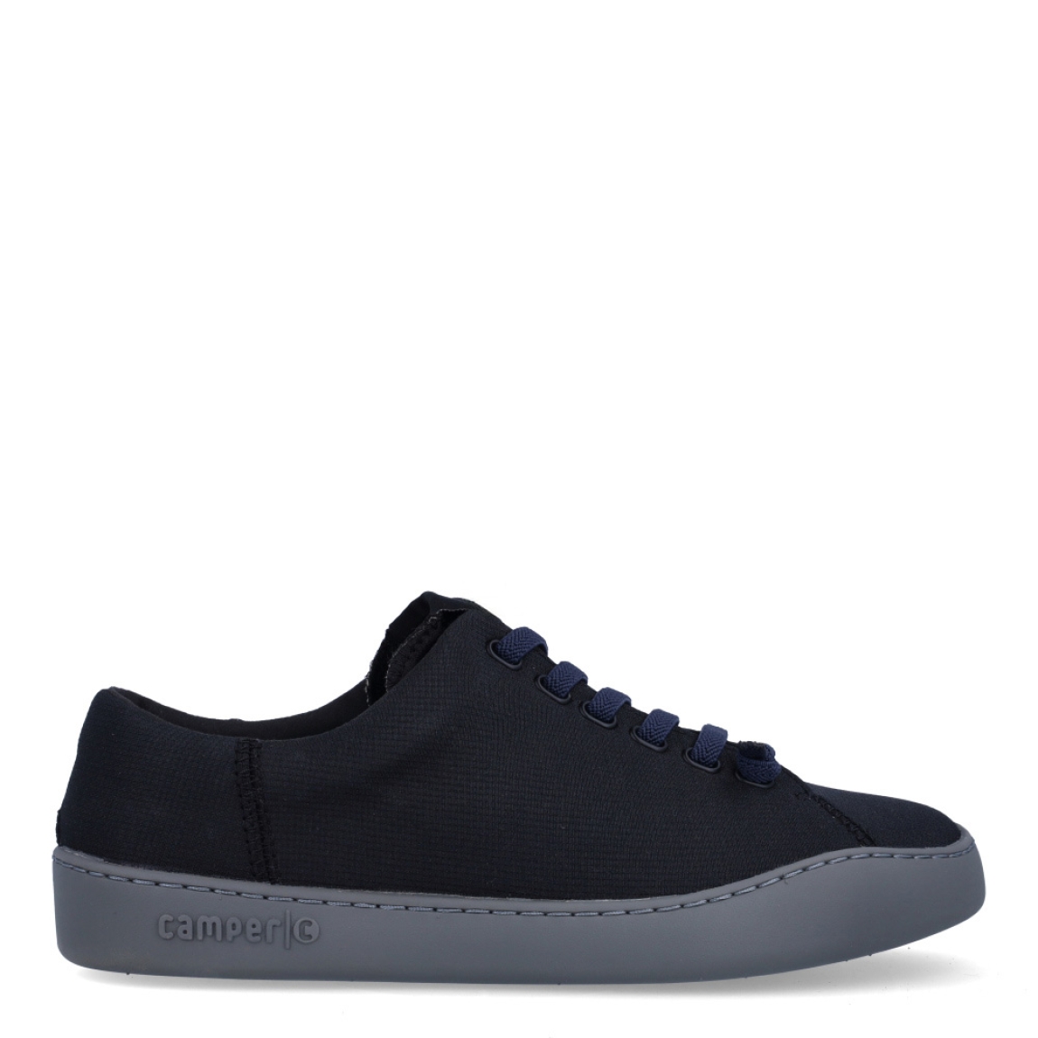 Deportivas clásicas de la marca Camper, modelo K10. Exterior en naylon color negro. Interior con plantilla color rojo. Cierre con cordones negros. Suela de goma plana color negro. Estas deportivas Camper K10 son un complemento ideal para disfrutar de la comodidad al caminar.