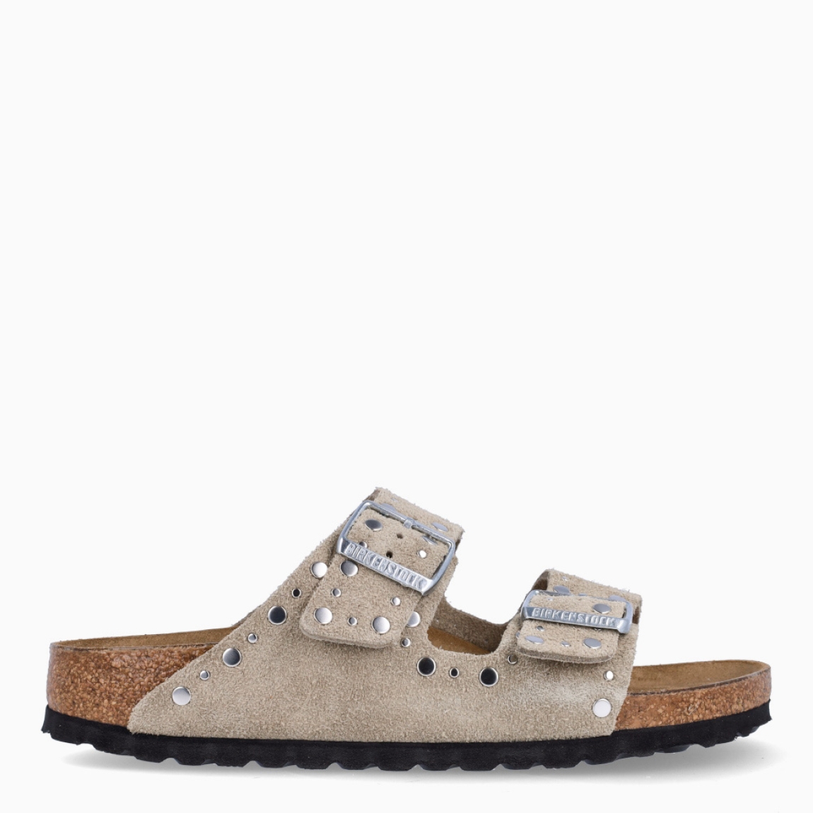 Sandalias de la marca Birkenstock, modelo ARIZONA RIVET. Sandalias elaboradas en ante de color taupe con detalle de tachuelas y con una base de corcho y látex de forma anatómica. Cierre de las sandalias con doble hebilla de espiga de metal con ajuste individual. Estas sandalias Birkenstock ARIZONA RIVET es un complemento clásico para tus looks de temporada, con un diseño sencillo atemporal y una ligereza que te dará la comodidad que necesitas en tu día a día.