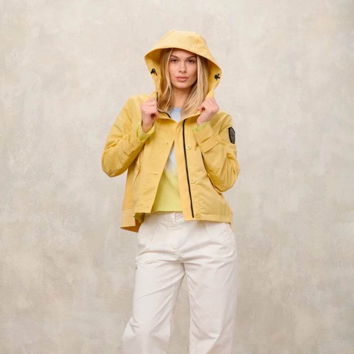 Chaqueta corta de la marca Blauer, modelo MARCELLA. Chaqueta de moda en nylon brillante color amarillo en el delantero y neopreno en tonalidad en la capucha, en el trasero y en la solapa con cremallera interna. Prenda ligeramente más larga en la espalda para dar un estilo único y característico ideal para las estaciones intermedias. Chaqueta Blauer con capucha fija, cierre con cremallera y botones, bolsillos con botón, bolsillos internos con velcro y parche y presilla con logo. Chaqueta Blauer MARCELLA, complemento ideal para esta temporada!