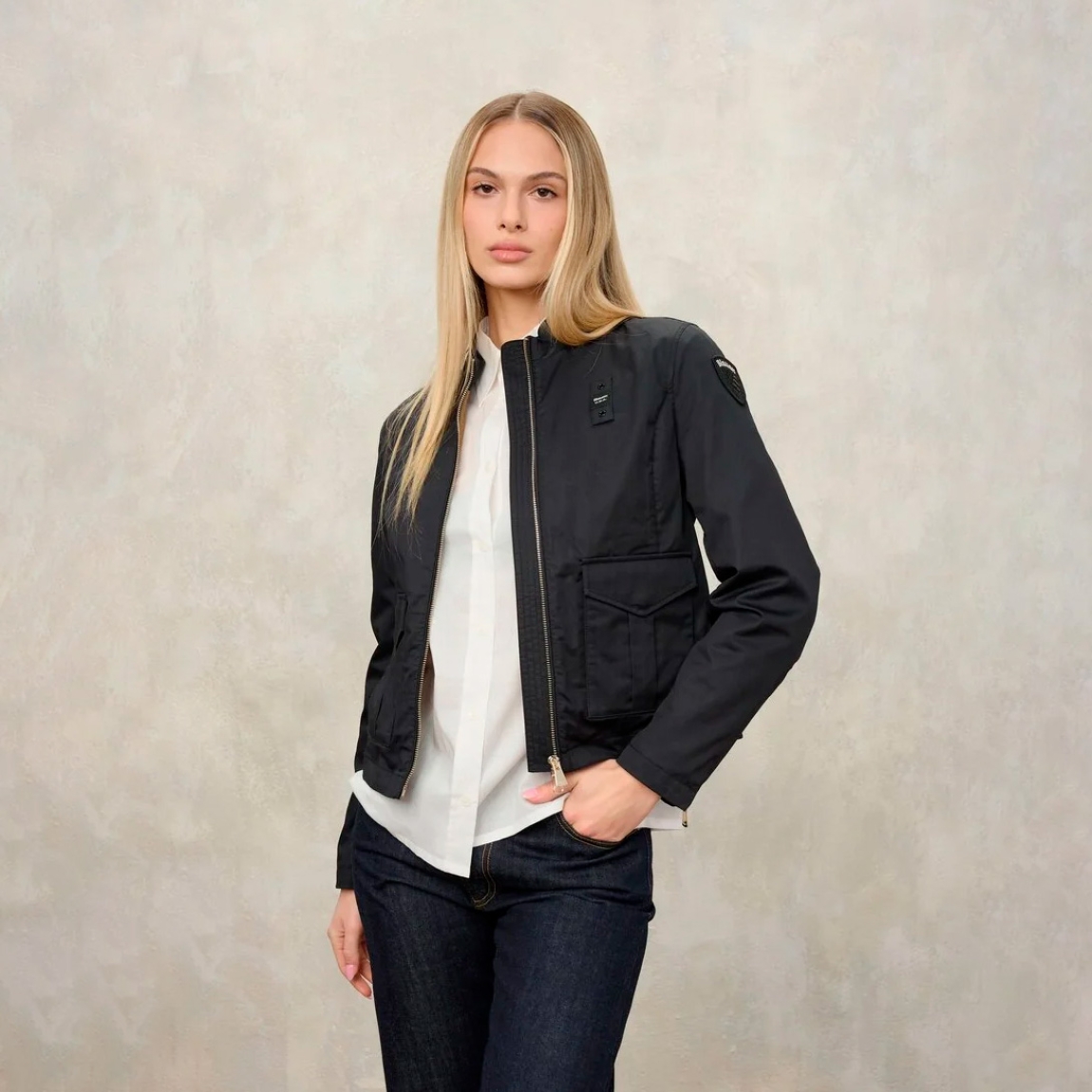 Chaqueta de la marca Blauer, modelo BLAKE. Chaqueta de algodón en color negro con cuello coreano. Las líneas son fluidas y esenciales con detalles modernos y refinados para un estilo casual pero elegante. Cierre de chaqueta Blauer con cremallera, bolsillos dobles abiertos y con automático, puño cerrado con cremallera profunda, bolsillo interno con Velcro. Parche y presilla con logo. Chaqueta Blauer BLAKE, complemento ideal para temporada!