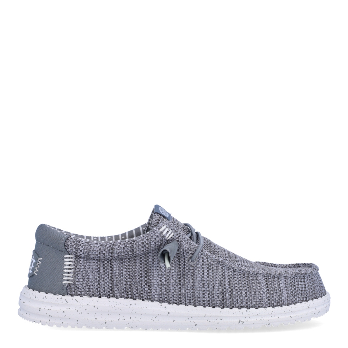 Náuticos de la marca Hey Dude, modelo WALLY STRECH. Exterior de los náuticos en tela color gris. Interior de los náuticos en tela con estampado gris y plantilla acolchada y extraíble. Cierre de los náuticos Hey Dude con cordones elásticos y suela plana de goma. Estos náuticos Hey Dude WALLY STRECH, son el complemento perfecto para esta temporada, los podrás lucir con la máxima comodidad posible.