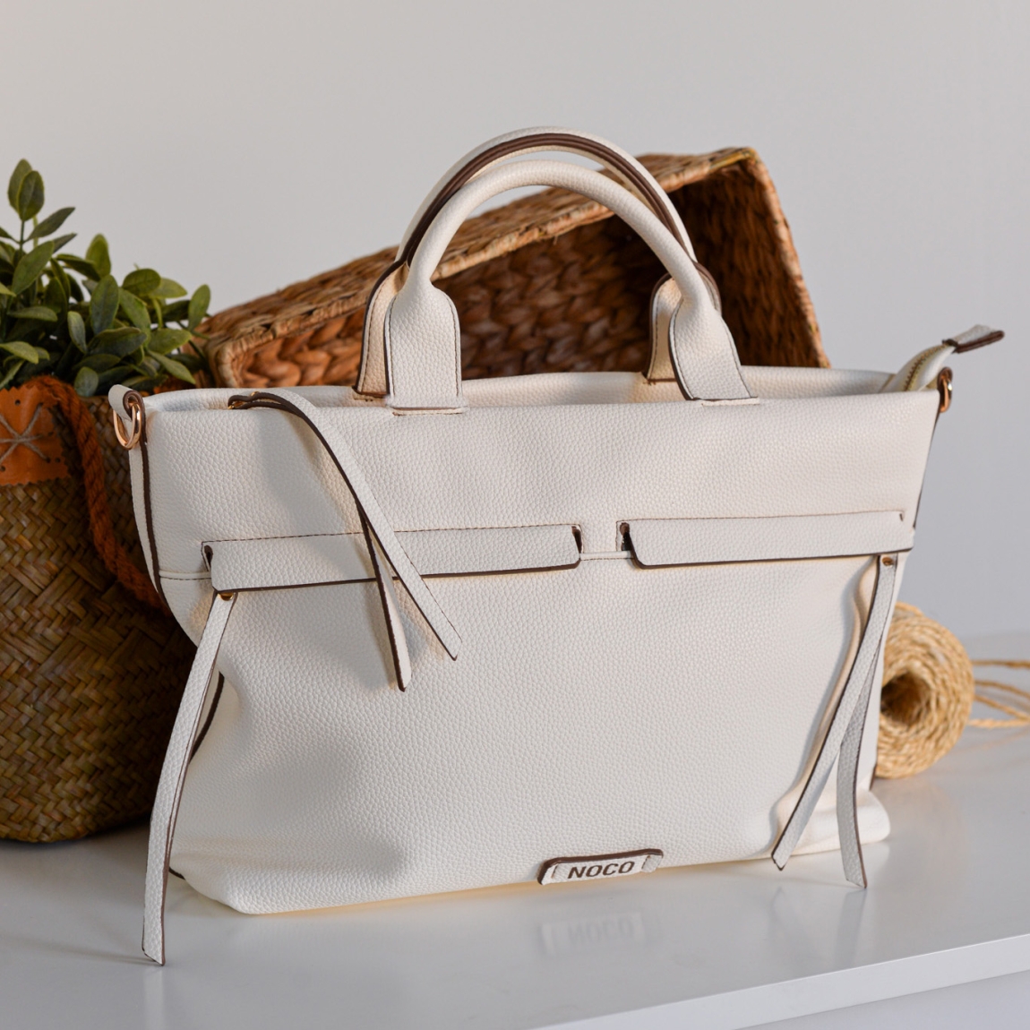 Bolso shopper Noco, modelo ELVIRA. Elaborado de piel vegana color blanco. Este bolso es una pieza única que combina estilo y sostenibilidad. Su formato se distingue por su trabajo de diseño original, aportando una forma sofisticada y funcional. Bolso Noco con cierre de cremallera. Bolso incluye una correa larga que permite usarlo cómodamente como bolso cruzado, adaptándose a tus necesidades y brindando mayor versatilidad. Medidas alto 26cm y ancho 38cm. Este bolso NOCO ELVIRA es ideal para ti!