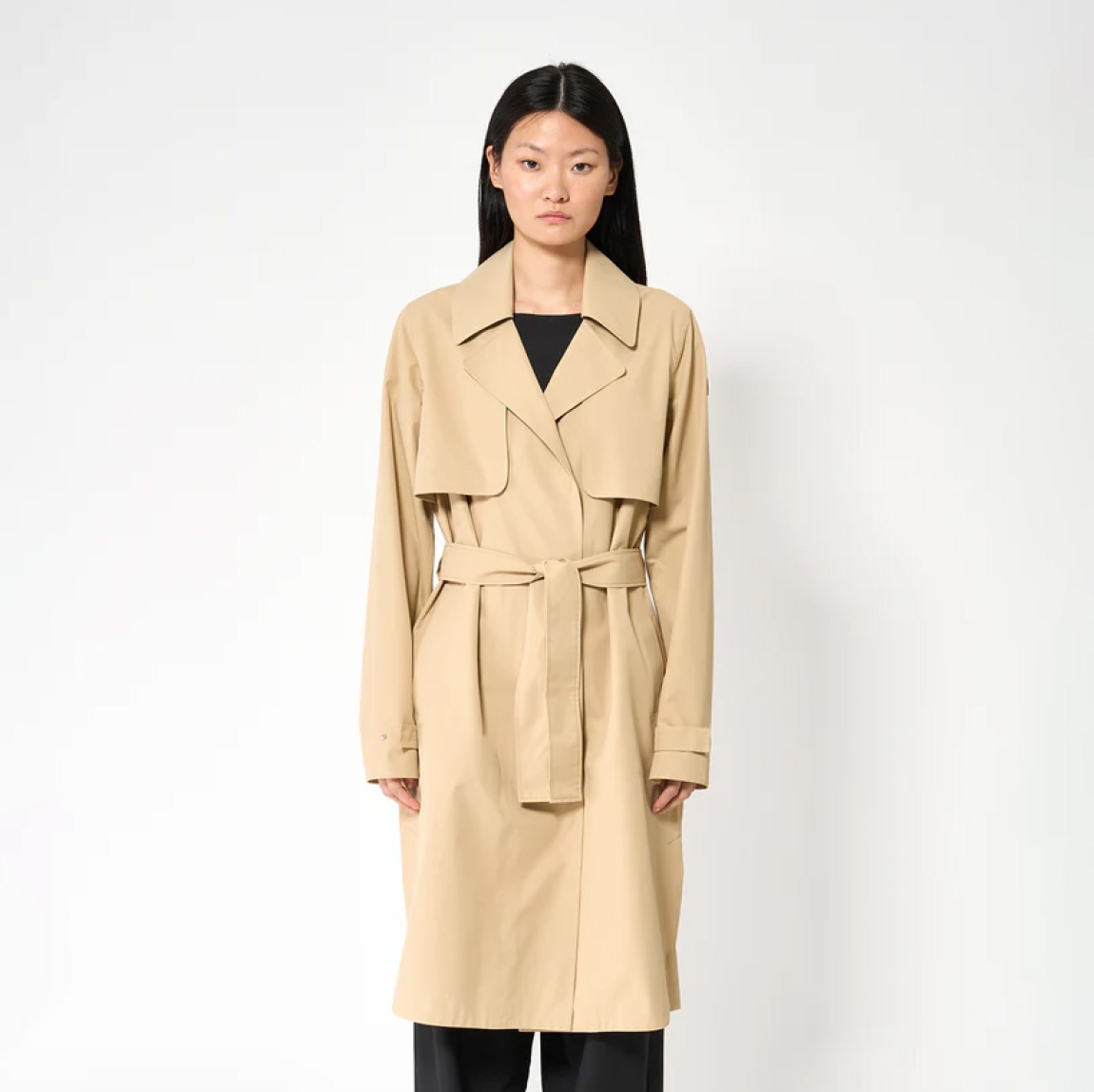 Chaqueta impermeable sin costuras de la marca Tanta, modeloTage. Chaqueta confeccionada en tejido de sarga de poliéster color camel. Es 100% impermeable y cuenta con todas las costuras selladas para una protección superior. Los detalles de la prenda incluyen dos canesús en la parte delantera y uno en la parte trasera, botones a presión ocultos, una cintura ajustable con cinturón y una capucha desmontable con cordón ajustable. Diseñado con un corte impecable, el modelo Tage combina elegancia con una alta funcionalidad.