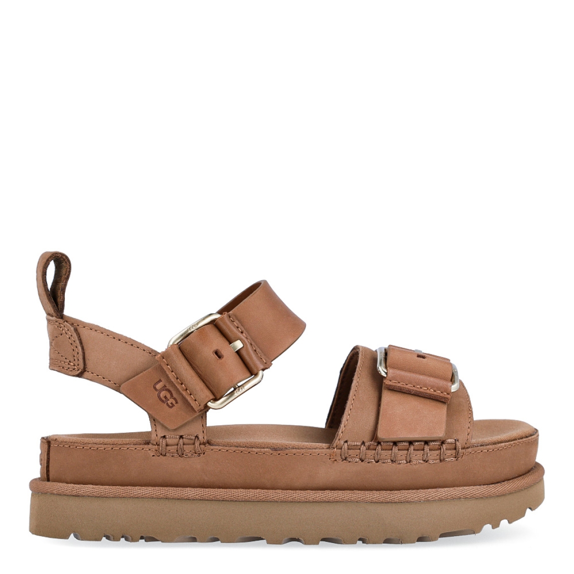 Sandalias de la marca UGG, modelo Goldenstar Villa. Elaboradas en piel color marrón con tiras en la pala. Estas sandalias UGG son ligeras y muy cómodas gracias a la suela de EVA de caña de azúcar y la plantilla contorneada, que las hacen ideales para explorar la ciudad o cualquier otro destino. Las tiras están hechas de una combinación de nobuk suave y piel auténtica y cuentan con una hebilla ajustable en el tobillo para que las adaptes como quieras. Con plataforma de 4cm de altura. Estas UGG Goldenstar Villa, que cuentan con elementos emblemáticos como los ribetes con costuras y detalles de pespunte cuadrado, te permiten disfrutar de la increíble sensación UGG® también durante los meses más cálidos.