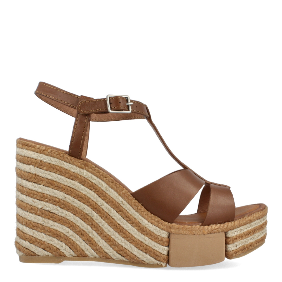 Sandalias de la marca Casteller, modelo BRUNA. Exterior e interior de las sandalias en piel color marrón. Cierre de las sandalias con hebilla en el tobillo. Sandalias Casteller con cuña de 10cm de altura con diseño de ondas. Estas sandalias Casteller BRUNA son unas clásicas para temporada, podrás crear diferentes looks con la máxima comodidad posible.