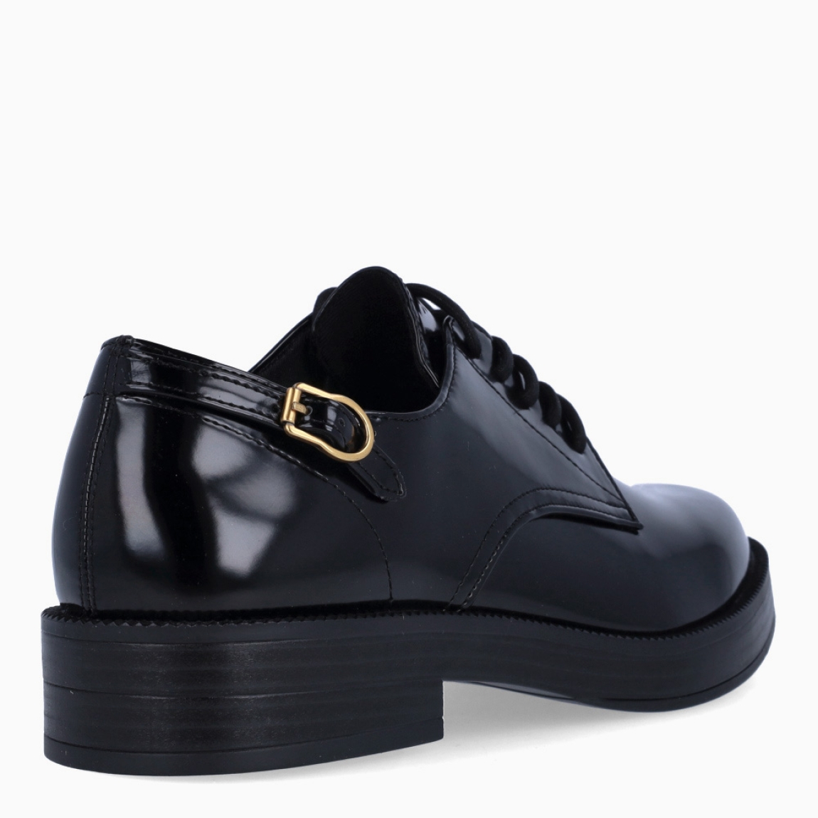 Blucher clásico de la marca Tamaris, modelo EIRA. Exterior del blucher de charol color negro. Interior del blucher de piel de color gris y negro. Cierre del blucher con cordones y detalle de hebilla a un costado. Blucher con suela de goma y cuña baja de 2 cm de altura. Estos blucher son ideales para crear diferentes looks desde la comodidad!