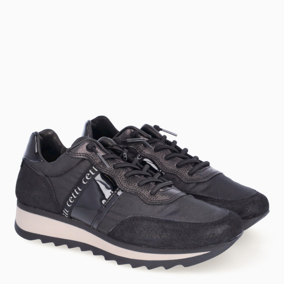 Deportivas de la marca Cetti, modelo C-849. Exterior de las deportivas en naylon color negro con efecto brillante. Interior de las deportivas en piel color negro. Cierre de las deportivas Cetti con cordones elásticos. Deportivas con cuña de 3cm de altura. Estas deportivas Cetti C-849 son unas clásicas, con estilo y comodidad que no pueden faltar en tu armario.