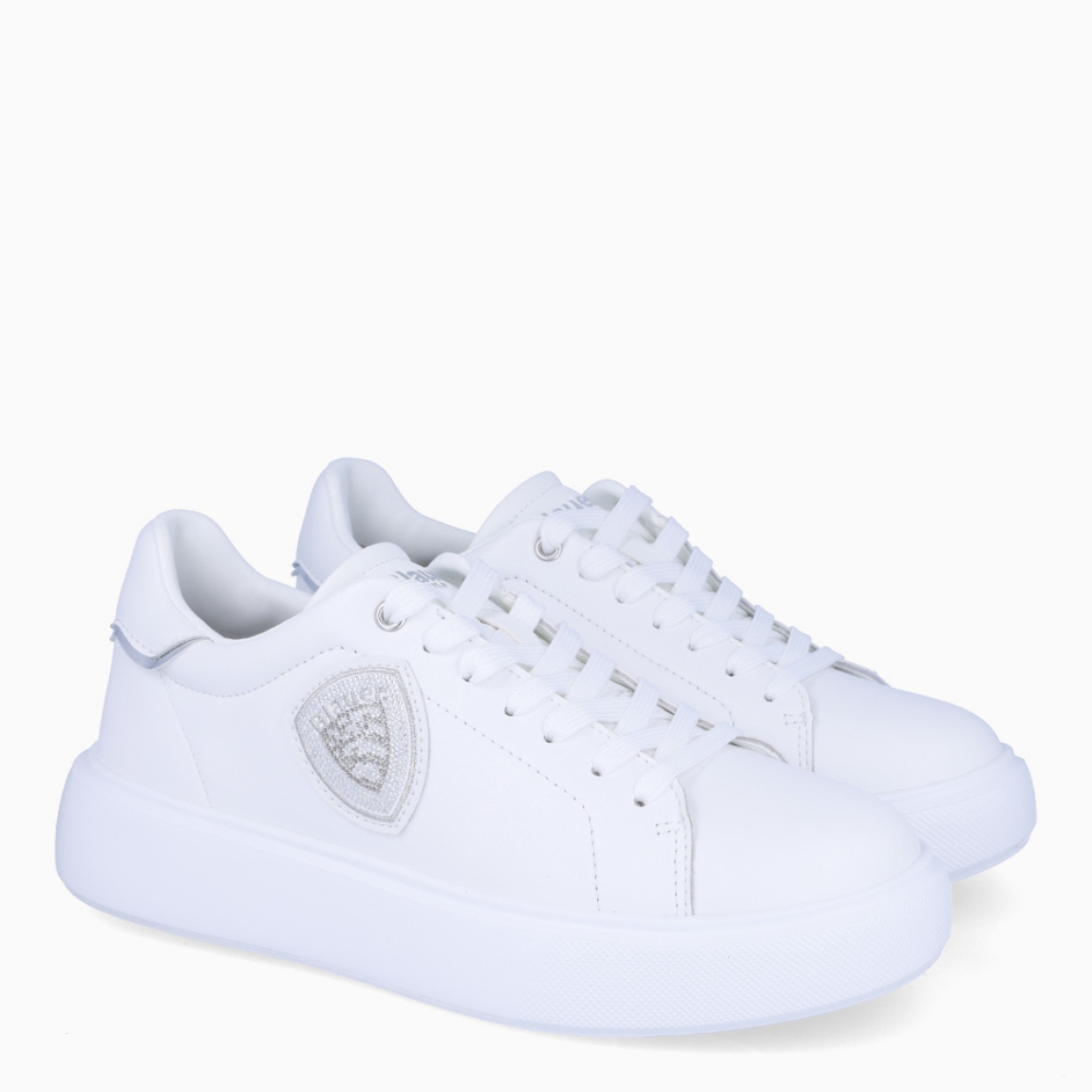 Deportiva de la marca Blauer, modelo VENUS. Exterior del la deportiva de piel de color blanco. Interior de la deportiva de piel y de forro textil. Logotipo blauer de pedrería plateada en el lateral exterior. Cierre de la deportiva con cordones. Deportiva con cuña de 3,5 cm de plataforma. La deportiva de Blauer, modelo VENUS, es una deportiva muy cómoda e ideal para el invierno. Queda bien con todo y es una pieza clave para dar un toque estiloso a tus looks de invierno.