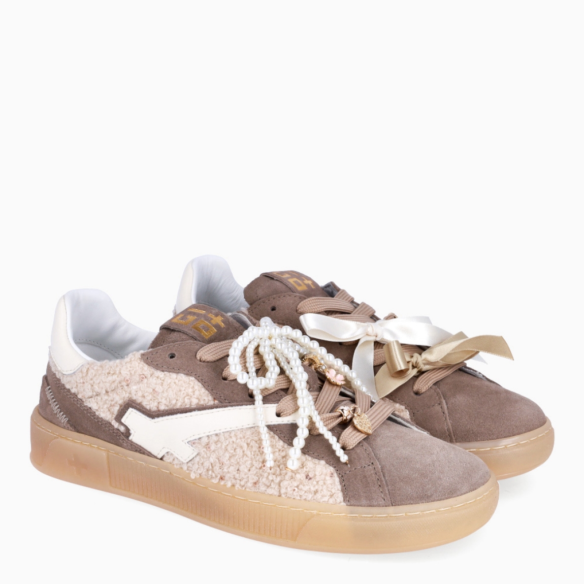 Deportivas de la marca GIO+, modelo BLUE. Exterior en ante color taupe con detalle en peluche y lazo en perlas y dije en la pala sujetada a cordones. Interior de las deportivas en piel color blanco con plantilla acolchada y extraíble para máxima comodidad. Cierre de las deportivas con cordones taupe y plataforma de 2cm de altura. Estas deportivas GIO+ BLUE tienen un estilo tendencia en esta temporada. No puede faltar en tu armario!
