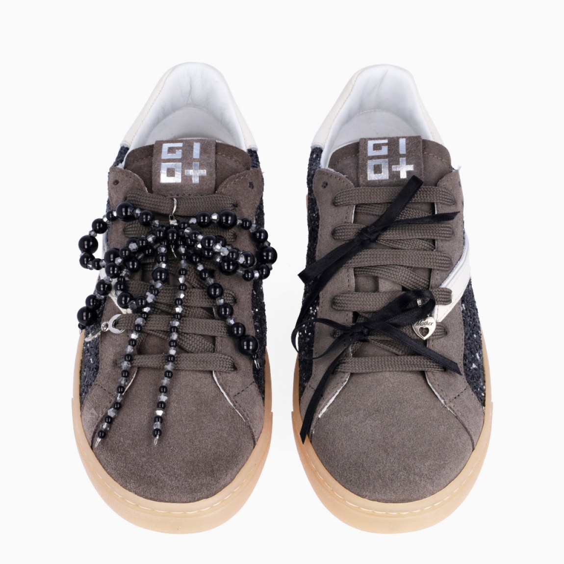 Deportivas de la marca GIO+, modelo BLUE. Exterior en ante color gris con detalle en glitter y lazo en perlas negras y dije en la pala sujetada a cordones. Interior de las deportivas en piel color blanco con plantilla acolchada y extraíble para máxima comodidad. Cierre de las deportivas con cordones gris y plataforma de 2cm de altura. Estas deportivas GIO+ BLUE tienen un estilo tendencia en esta temporada. No puede faltar en tu armario!