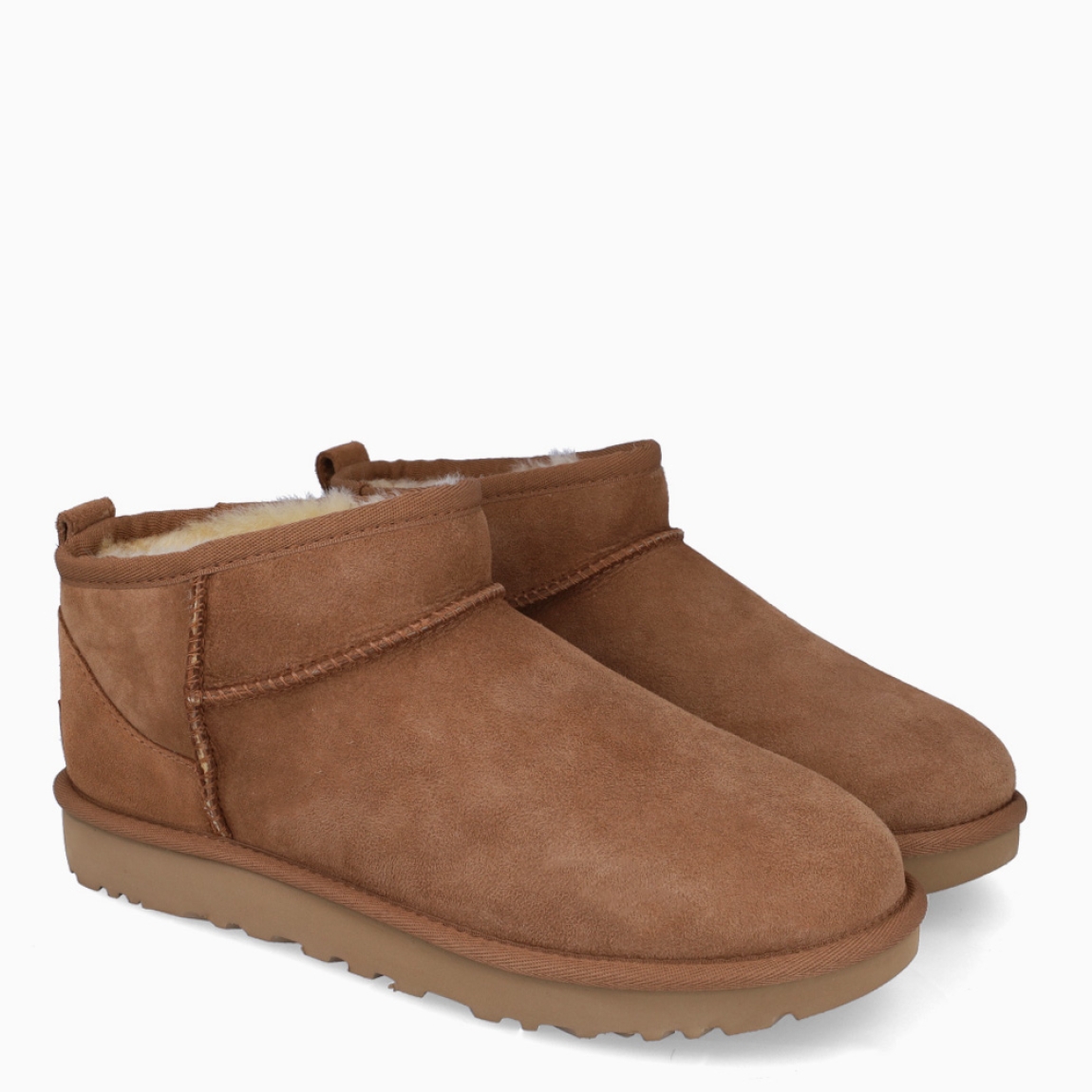 Botines CLASSIC ULTRA MINI de la marca UGG, en color CHESTNUT. Exterior en ante de piel de oveja color marrón claro. Tratamiento higrófugo aplicado en el exterior. Forro y plantilla de pelo de oveja acolchado. Suela plana de goma EVA de caña de azucar. Altura de la caña 8,9cm. Estos botines UGG Classic Ultra Mini son uno de los clásicos más codiciados de UGG, un diseño con una caña más baja que facilita ponérselas y quitárselas.