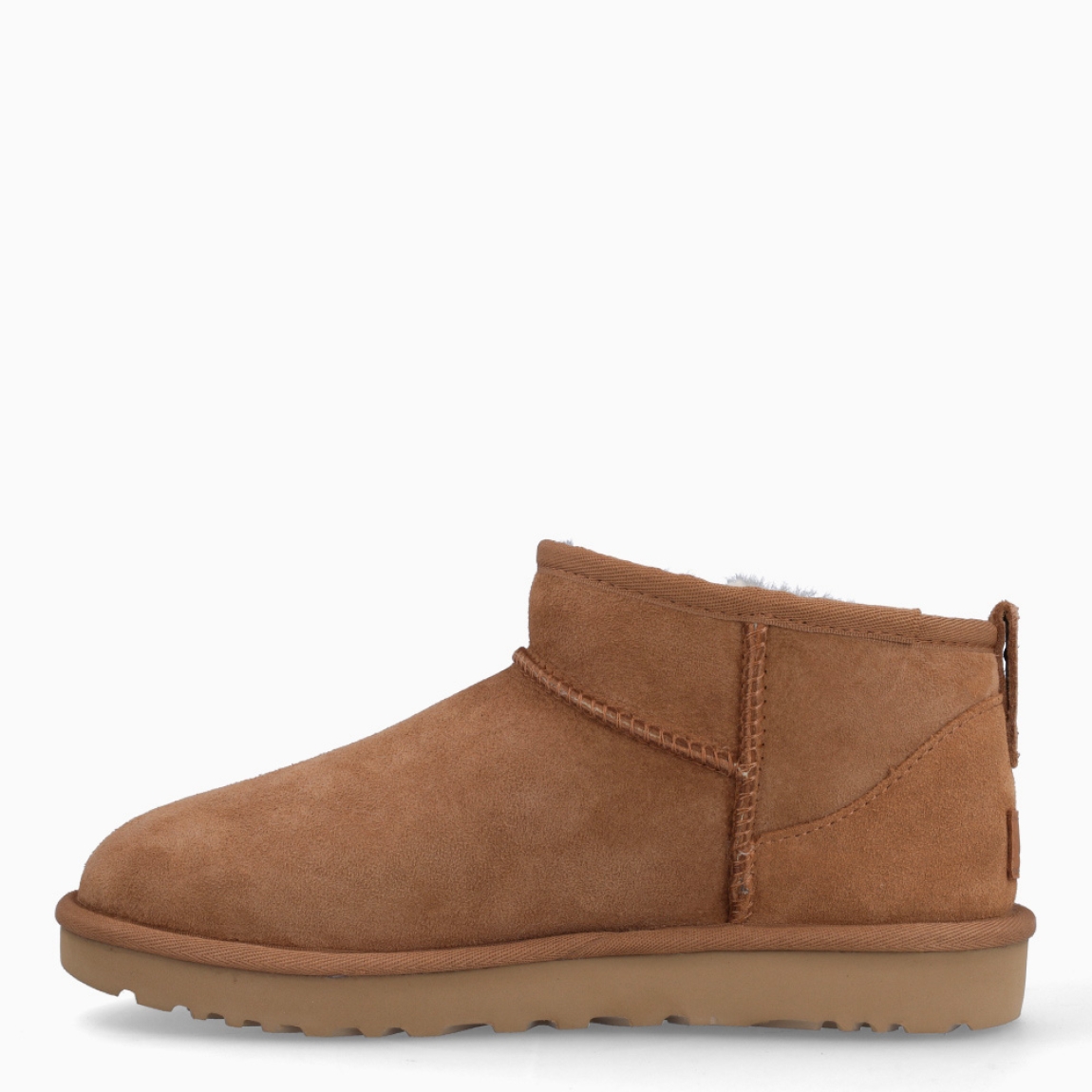 Botines CLASSIC ULTRA MINI de la marca UGG, en color CHESTNUT. Exterior en ante de piel de oveja color marrón claro. Tratamiento higrófugo aplicado en el exterior. Forro y plantilla de pelo de oveja acolchado. Suela plana de goma EVA de caña de azucar. Altura de la caña 8,9cm. Estos botines UGG Classic Ultra Mini son uno de los clásicos más codiciados de UGG, un diseño con una caña más baja que facilita ponérselas y quitárselas.
