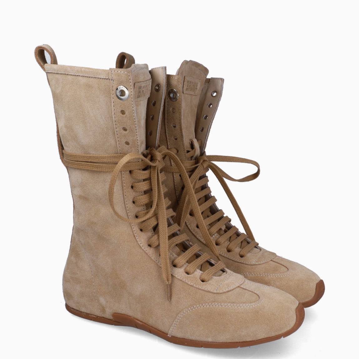 Botines de la marca Bronx, modelo BOXING. Exterior en ante color camel con punta redonda. Cierre con cordones cruzados en toda la pala. Interior en piel color camel. Suela de goma plana. Botines Bronx BOXING ideales para ti!
