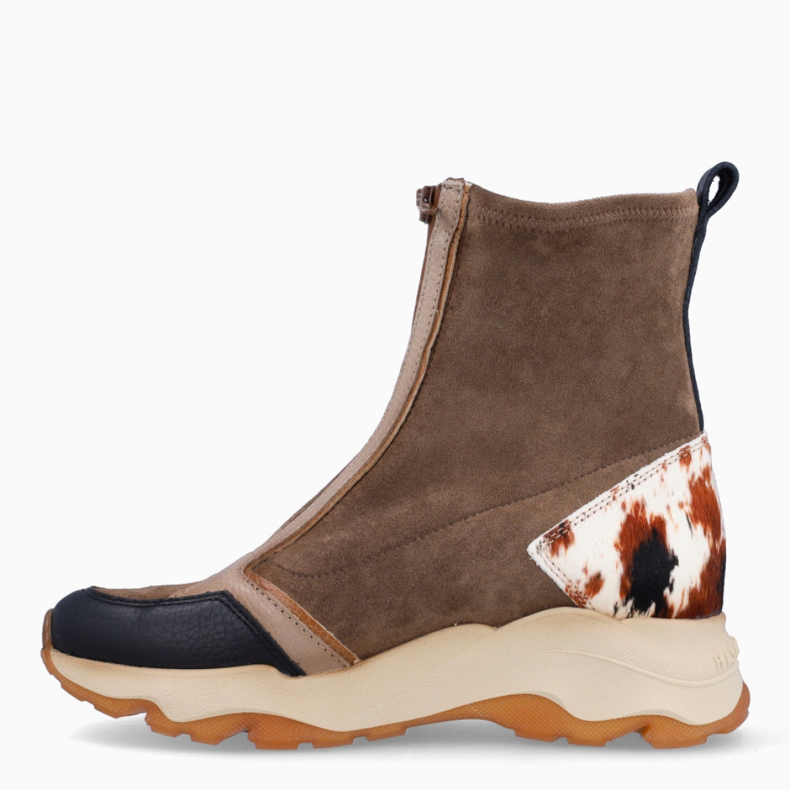 Botines de la marca Hispanitas, modelo NEPAL. Exterior ante color taupe con punta redonda y detalle de estampado animal print de vaca en talón. Interior en piel color marrón. Cierre con cremallera. Estos botines Hispanitas NEPAL son ideales para dar estilo y comodidad a tus looks de temporada!