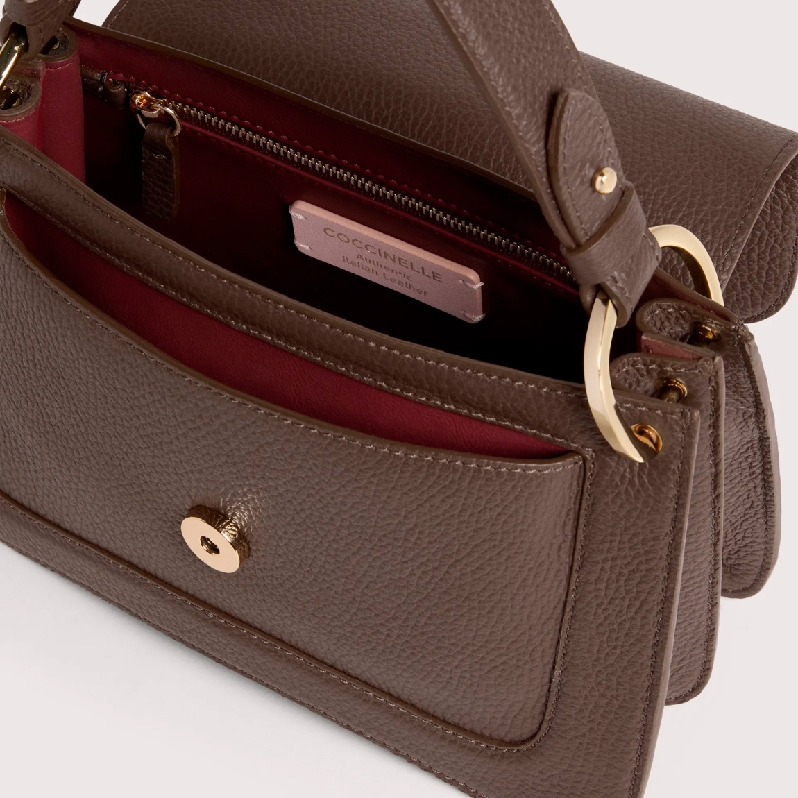 Bolso bandolera de la marca Coccinelle, modelo C-ME. Exterior en piel color marrón con detalle de logo en parte frontal. Interior con compartimentos. Cierre con botón inmantado y doble asa, de mano y hombro. Medidas: alto 15cm y ancho 24cm. Este bolso Coccinelle C-ME es un complemento sofisticado, ideal para combinar con tus looks de temporada!