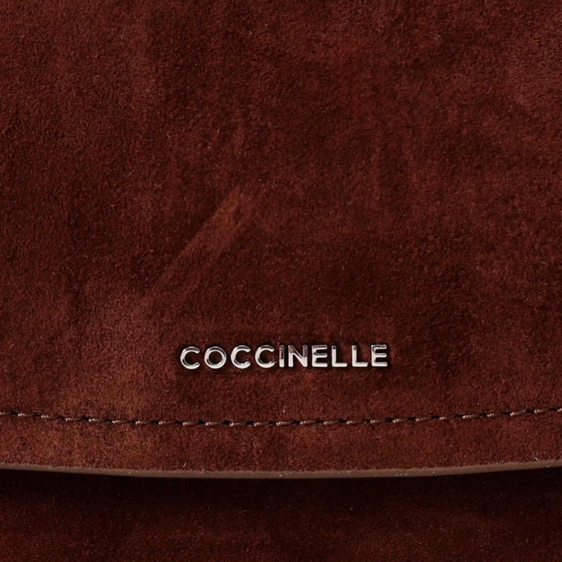 Bolso clasico de la marca Coccinelle, modelo REBEKKA. Exterior en ante color marrón con detalle de logo en parte frontal. Interior amplio. Cierre con iman y asa bandolera. Medidas: alto 22cm y ancho 30cm. Este bolso Coccinelle REBEKKA es un complemento sofisticado, ideal para combinar con tus looks de temporada!