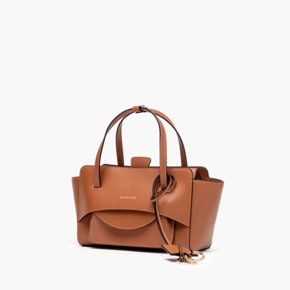Bolso de la marca Hidesins, modelo FLAP S. Elaborado en piel de alta calidad color marrón con estampado de logotipo en frente. Bolso con botón magnético, correa bandolera ajustable y extraíble. Herrajes metálicos chapados en oro y bolsillos interiores. Medidas: alto 14cm y ancho 22cm. Este bolso Hidesins FLAP S está confecciado con elegancia, un complemento ideal para resaltar tus looks!