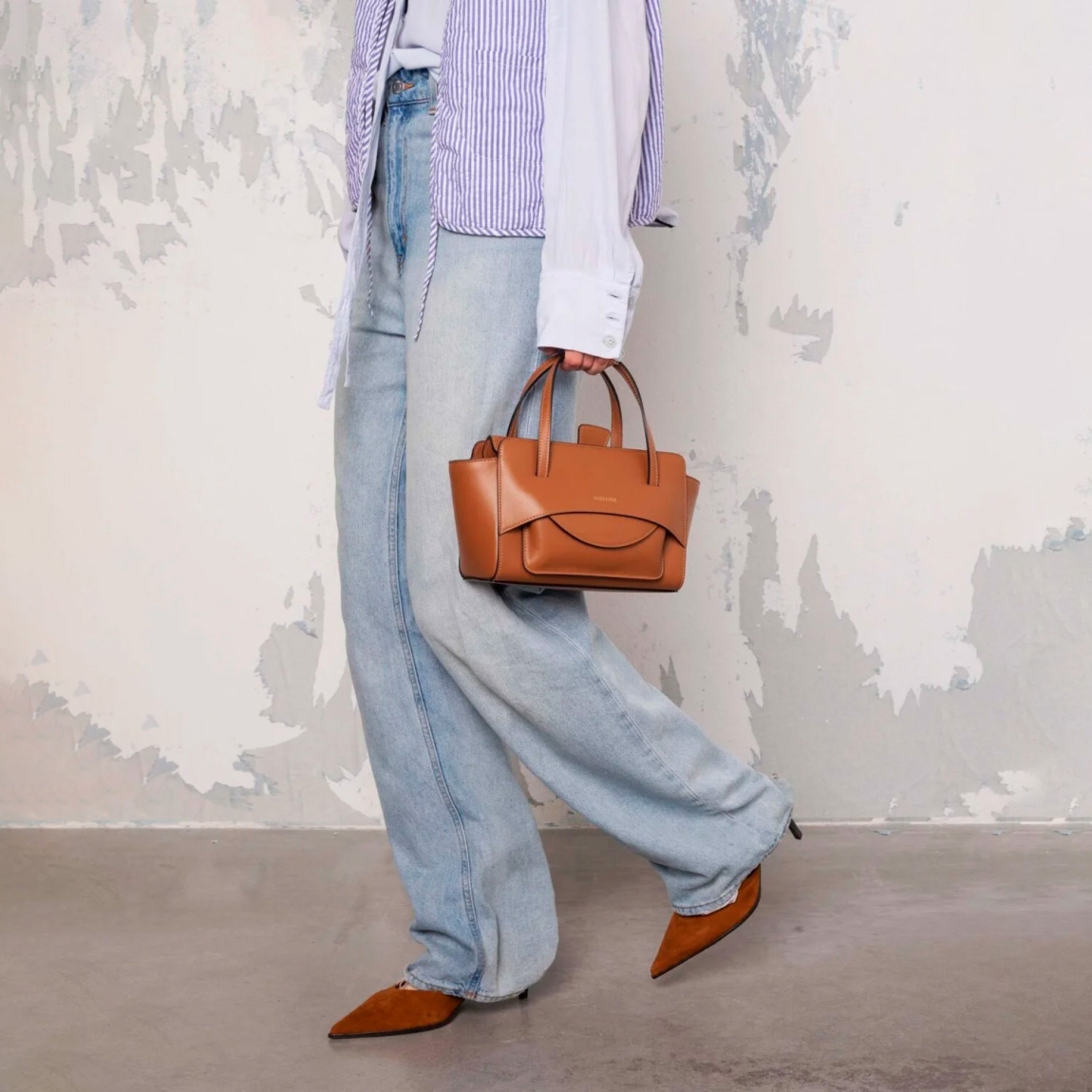 Bolso de la marca Hidesins, modelo FLAP S. Elaborado en piel de alta calidad color marrón con estampado de logotipo en frente. Bolso con botón magnético, correa bandolera ajustable y extraíble. Herrajes metálicos chapados en oro y bolsillos interiores. Medidas: alto 14cm y ancho 22cm. Este bolso Hidesins FLAP S está confecciado con elegancia, un complemento ideal para resaltar tus looks!