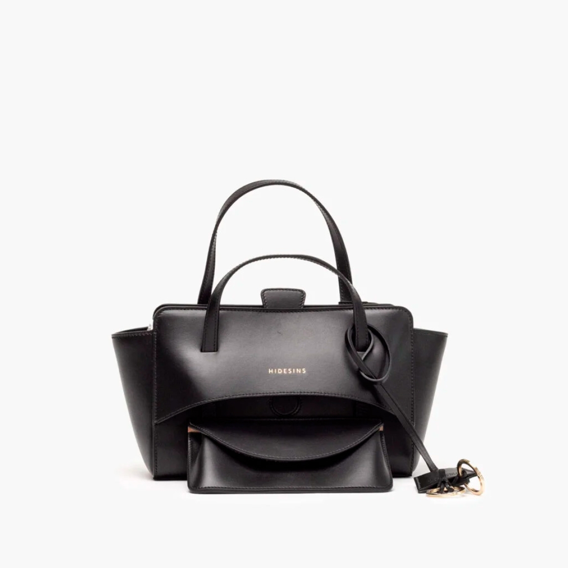Bolso de la marca Hidesins, modelo FLAP S. Elaborado en piel de alta calidad color negro con estampado de logotipo en frente. Bolso con botón magnético, correa bandolera ajustable y extraíble. Herrajes metálicos chapados en oro y bolsillos interiores. Medidas: alto 14cm y ancho 22cm. Este bolso Hidesins FLAP S está confecciado con elegancia, un complemento ideal para resaltar tus looks!