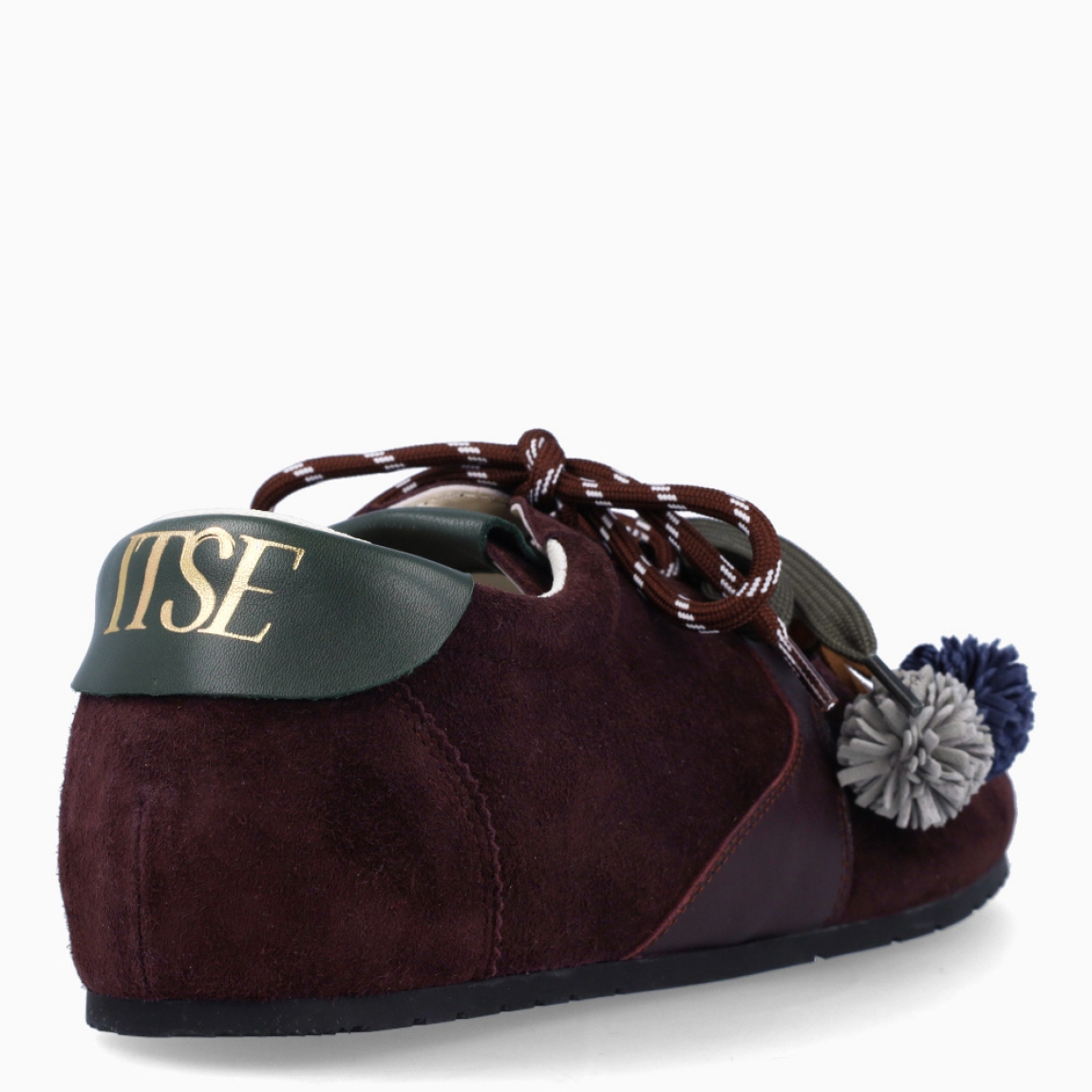 Deportivas de la marca Itse, modelo SALMA. Exterior en ante color marrón granate. Interior en textil color blanco. Cierre con cordones dobles, uno marrón y otro, verde. Deportivas Itse con tres charms sujetados a los cordones en forma de pompones y flor azul. Suela plana y de goma. Estas deportivas Itse Salma son un complemento básico y en tendencia para tus looks!