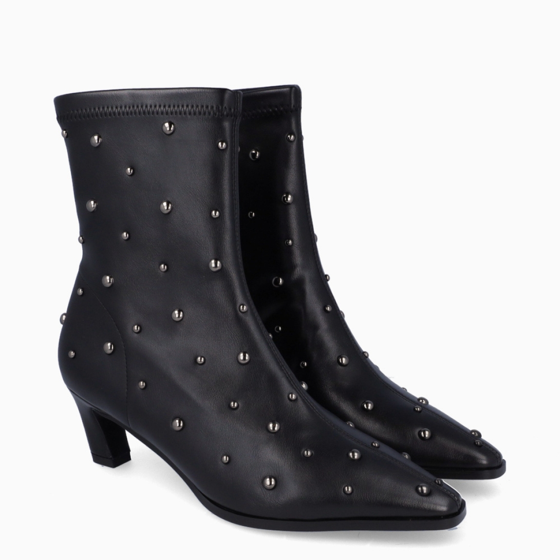 Botines de la marca Itse, modelo TRIANA. Exterior en piel color negro con punta lápiz y detalle de tachuelas plateadas. Interior en piel color negro con plantilla acolchada para máxima comodidad. Cierre con cremallera y una suela de goma con tacón de punta fina con 5cm. Estos botines Itse TRIANA son un complemento ideal para estilizar y darle personalidad a tus looks!