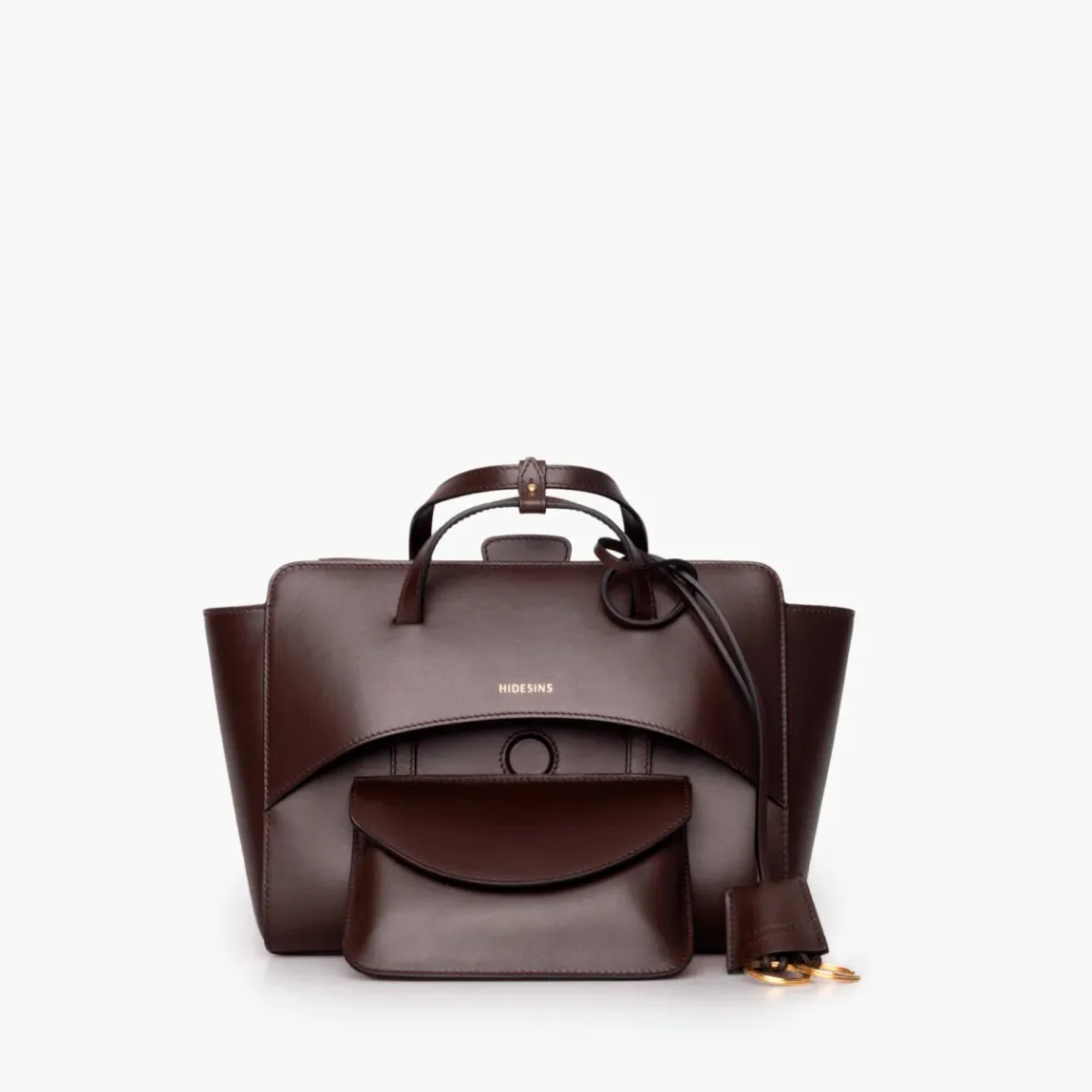 Bolso de la marca Hidesins, modelo FLAP M. Elaborado en piel de alta calidad color marrón con estampado de logotipo en frente. Bolso con botón magnético, correa bandolera ajustable y extraíble. Herrajes metálicos chapados en oro y bolsillos interiores. Medidas: alto 18cm y ancho 26cm. Este bolso Hidesins FLAP M está confeccionado con elegancia, un complemento ideal para resaltar tus looks!