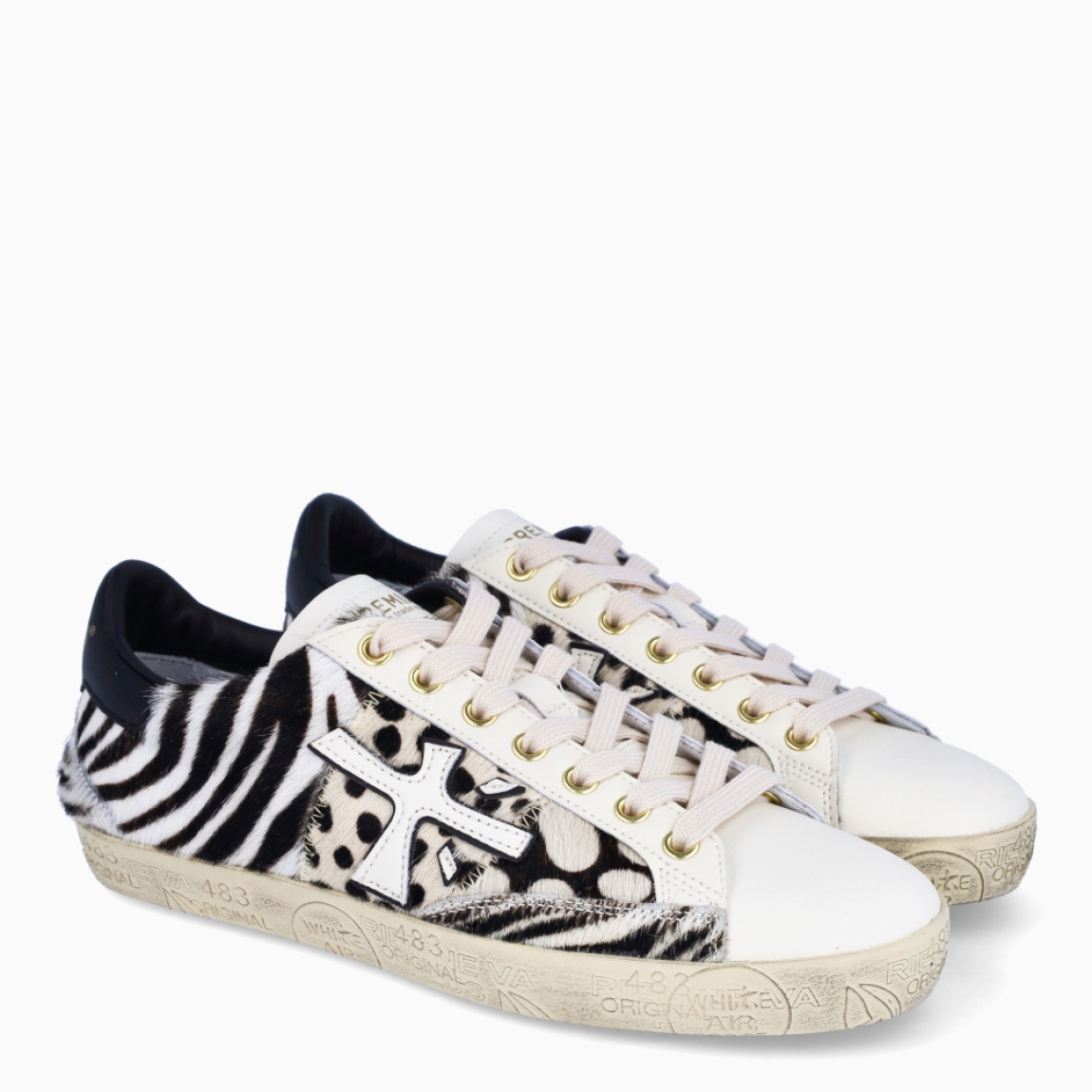 Deportivas de la marca Premiata, modelo STEVEND. Exterior de las deportivas en piel color blanco con detalle de animal print de cebra. Logo de color blanco. Interior de las deportivas en piel color negro. Cierre de las deportivas con cordones blancos. Deportivas Premiata Stevend tienen el diseño perfecto para temporada, no puede faltar este modelo clásico en tu armario!