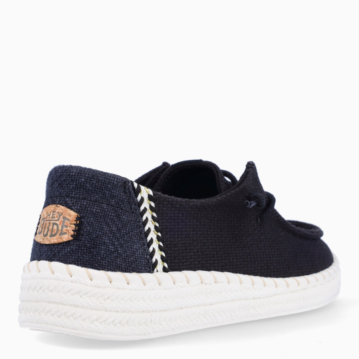 Náuticos transpirables de la marca Hey Dude, modelo WENDY. Exterior de los náuticos en textil color negro. Interior en textil color negro. Cierre de los náuticos Hey Dude con cordón elástico. Naúticos con suela de goma con 3cm de cuña. Estos náuticos Hey Dude WENDY son el complemento clásico que necesitas esta temporada. No te puede faltar en tu armario.