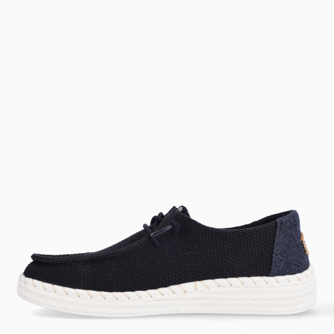 Náuticos transpirables de la marca Hey Dude, modelo WENDY. Exterior de los náuticos en textil color negro. Interior en textil color negro. Cierre de los náuticos Hey Dude con cordón elástico. Naúticos con suela de goma con 3cm de cuña. Estos náuticos Hey Dude WENDY son el complemento clásico que necesitas esta temporada. No te puede faltar en tu armario.